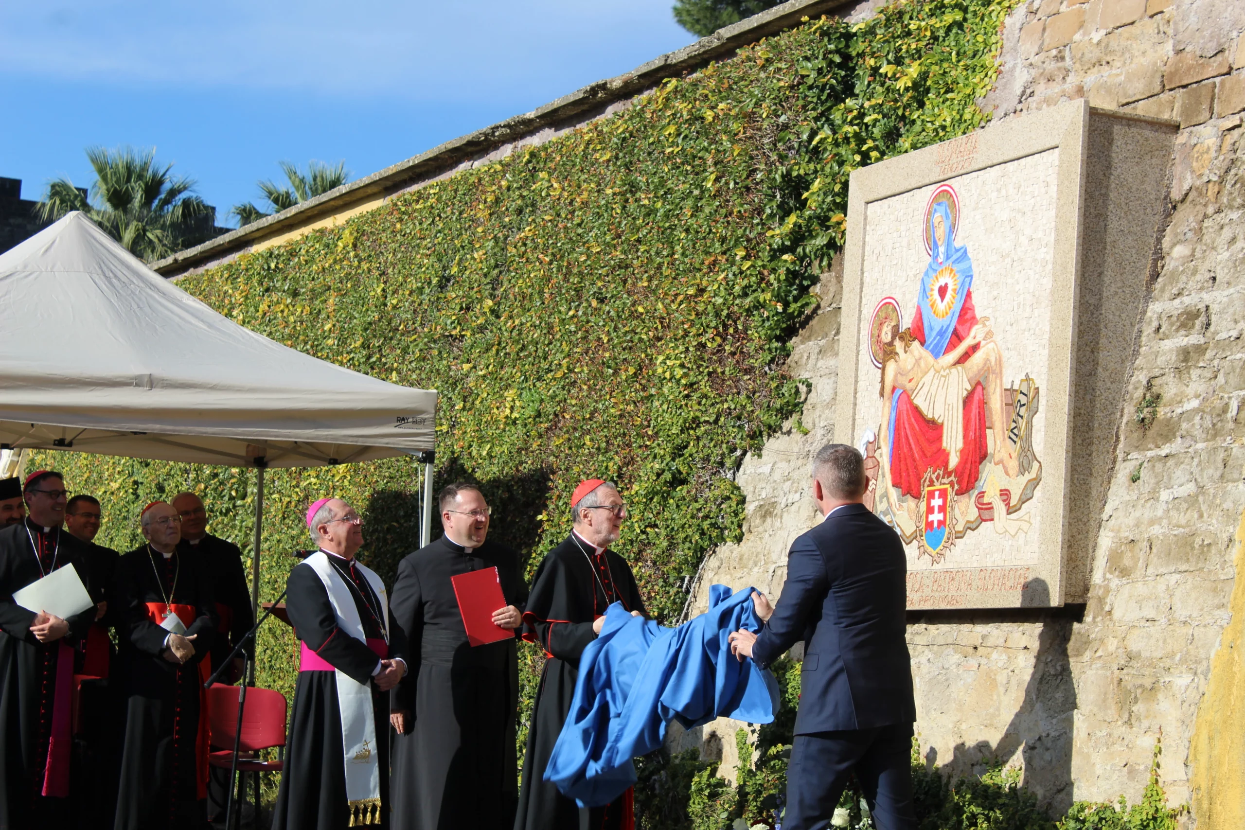New Slovak Virgin Mary mosaic highlights spiritual bonds between Slovakia and Vatican – #Catholic – 
 
 Archbishop Bernard Bober of Košice, president of the Slovak Bishops’ Conference, blesses the new mosaic of Our Lady of Sorrows in the Vatican Gardens at a ceremony attended by Slovak President Peter Pellegrini and Vatican officials on Dec. 5, 2025 / Credit: Bohumil Petrík

EWTN News, Dec 6, 2025 / 08:00 am (CNA).
Just before the feast of the Immaculate Conception, a mosaic of Our Lady of Sorrows, Protectress of Slovakia, was inaugurated in the Vatican Gardens. Archbishop Bernard Bober of Košice, president of the Slovak Bishops’ Conference, blessed the artwork during a ceremony attended by Slovak President Peter Pellegrini, whom Pope Leo XIV received in audience the day before.Among other bishops and diplomats, two cardinals took part: the dean of the College of Cardinals, Cardinal Giovanni Re, and Cardinal Claudio Gugerotti, prefect of the Dicastery for the Eastern Churches.Slovak President Peter Pellegrini and Cardinal Claudio Gugerotti unveil the new Slovak Our Lady of Sorrows mosaic in the Vatican Gardens on Dec. 5, 2025. Credit: Bohumil PetríkThe Slovak president said he was happy to see the Slovak Virgin Mary image inside the Vatican as she “is a source of hope, faith and unity.” Peter Pellegrini stressed that his Central European country and the Holy See “share common values, such as the dignity of human person, true liberty and open dialog.”During the audience with Pope Leo XIV, the Vatican said, pontiff and president reaffirmed their commitment to supporting social cohesion, promoting justice, and safeguarding the family, and discussed the war in Ukraine, its impact on European security, and the situation in the Middle East.Each time we pass by this beautiful artwork, Cardinal Gugerotti underlined in his speech at the inauguration, “we will pray for the Slovak people” who suffered during atheist communism, and yet “were able to maintain and renew its Christian roots.”Likewise, Cardinal Giovanni Re told CNA that he is very happy for the new artwork. “I have always loved Slovakia because it is still very Catholic,” the prelate said.It is a great honor for us that the mosaic of Our Lady of Sorrows has reached the heart of the Church, Archbishop Bober underscored. The Slovak Virgin Mary is “a symbol of the spiritual connection between Slovakia and the Vatican.” It reminds us, the archbishop continued, that “Our Lady of Sorrows has a special place in our nation, but also in the lives of all believers.”The colorful mosaic, created by Greek Catholic priest and artist Father Kamil Dráb, is a copy of an image in the chapel of the Pontifical Slovak College of St. Cyril and Methodius in Rome and has been installed in the Vatican Gardens near the bell used during the Great Jubilee of 2000.
