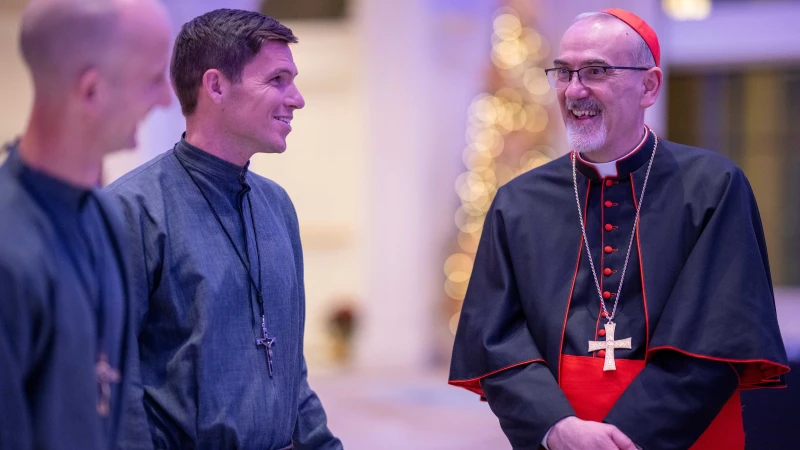 On visit to Detroit, patriarch of Jerusalem focuses on hope for Holy Land Christians – #Catholic –
Cardinal Pierbattista Pizzaballa, the Latin Patriarch of Jerusalem, speaks with members of Society of Our Lady of the Most Holy Trinity (SOLT), during a Dec. 5, 2025 fundraising dinner to support of Christians in the Holy Land at St. John's Resort in Plymouth, Michigan. / Credit: Courtesy of Detroit Catholic, photos by Tim Fuller.
Ann Arbor, Michigan, Dec 6, 2025 / 15:30 pm (CNA).
Cardinal Pierbattista Pizzaballa, the Latin Patriarch of Jerusalem, expressed cautious hope for peace in Gaza, calling on people of the region to combat hatred and “think differently” about each other. Pizzaballa, whose authority extends over Latin Catholics in Israel, Palestine, Jordan, and Cyprus, also holds the office of grand prior of the Order of the Holy Sepulchre. He began a four-day pastoral visit to metro Detroit on Dec. 4, celebrating Mass with the Chaldean community at St. Thomas Chaldean Catholic Church in West Bloomfield, Michigan. Detroit Archbishop Edward J. Weisenburger and Chaldean Bishop Francis Y. Kalabat joined him. Throughout the visit, the cardinal offered a sober yet grounded message of hope for Christians in the Holy Land.At a press conference on Dec. 5, Weisenburger welcomed the cardinal and praised his efforts to promote a “just and lasting peace” in Gaza. Asked by CNA what hope remains for Holy Land Christians amid what he had described as some of the worst devastation in decades, Pizzaballa cautioned against equating hope with immediate political solutions.“Hope is a complicated word,” he said. “You must not confuse hope with a political solution, which will not arrive soon, not in Gaza, the Holy Land, or the Palestinian-Israeli conflict. If you put your hope in this, you will be frustrated.” He emphasized that both political and religious institutions must work to nurture hope.“Hope,” the cardinal continued, “is a word that cannot remain alone. It has to put roots in something else,” namely, faith and desire. He added, “There needs to be a desire for it to be realized. A second consideration is that if institutions fail, we need people to think differently, to act differently, both Israelis and Palestinians. This may not resolve all the problems, but it says to people, ‘All is not lost.’”Christians represent only about 1% of Gaza’s population—roughly 500 people—and about 2% of the population in both Israel and the West Bank, where there are about 190,000 and 45,000 Christians, respectively. Many continue to emigrate, raising fears about the future of Christianity in the region. Gaza has only one Catholic parish, for example.The patriarch described the increasingly dire conditions in Gaza since the Oct. 7, 2023, Hamas terrorist attack on Israel. Most infrastructure—homes, hospitals, and schools—has been reduced to rubble, he said, leaving families in tents as winter approaches and food remains scarce. During a visit after Hamas and Israel concluded a ceasefire this fall, he brought food, including chicken, to Christians sheltering at the Holy Family parish compound. “It was the first meat they had seen in nine months,” he said. Although food enters Gaza, much of it ends up in markets, where many have no cash to purchase it, he said.Despite the devastation, sacramental life continues. Hosting some 500 displaced Gazans, the parish has school activities and daily liturgies, including Mass, Vespers, the Rosary, and Eucharistic Adoration. First Communions and even a wedding have taken place. The parish’s sacramental life has emboldened solidarity among those taking shelter at the church, but has been a spiritual aid, Pizzaballa said. “Every time I speak with them, I never hear a word of anger; never,” Pizzaballa said. “And one person, I can’t even say the name, he was the director of the hospital. One evening, in Gaza, between the bombs falling not far from the compound, he said, ‘You know, bishop, we Christians have a problem. Amidst all the violence, we are not able to hate them.’”While Israel and Hamas agreed to a ceasefire on Oct. 9, Pizzaballa said Gazans are only now emerging from “survival mode.” He said, “They ask, ‘What do we do now? When will rebuilding start? What governance will there be? Who will decide? What about our children?’ There was no emotional space for these questions before, but now they are coming out.”Weisenburger acknowledged the complexity of the situation, saying it cannot be “simplified into sound bites.” He reflected on the human cost of the war: “Too many of those bombs that killed some 70,000 people, wiped their homes from the face of the earth, and destroyed their cities, schools, and hospitals, were from us. I think we in America must accept some responsibility for rebuilding.” He expressed gratitude for the cardinal’s message of hope, adding that generous Detroiters had already pledged about 0,000 for needs in the Holy Land. “By doing something, we can nurture hope,” he said.In his homily at the Chaldean community Mass, Pizzaballa compared Isaiah’s vision of restoration with present-day devastation in the Middle East, including the suffering of Chaldeans in Iraq at the hands of ISIS. He stressed the Church’s mission of fostering peace. Regarding the Hamas attack, he said, “We have to say this very clearly: it is not acceptable at all.” He added, however, that Israel’s “retaliation, what happened after in Gaza, is an even more difficult answer.” He emphasized, “We are not against Israel,” while insisting that “The situation will never change as long as the Palestinians are not recognized as people with their dignity and a right of self-determination.”On Dec. 5, the cardinal visited fellow Franciscans at St. Bonaventure Monastery and prayed at the tomb of Blessed Solanus Casey. He received a first-class relic of Blessed Solanus to bring to Jerusalem. The Chaldean community also presented him with relics of four Chaldean martyrs. The next day, he visited Sacred Heart Seminary and spoke with seminarians and faculty.About 500 people attended the Dec. 5 fundraising dinner held at St. John’s Resort, the former seminary campus dedicated to charitable hospitality. Weisenburger said the resort’s owner, the Pulte Family Charitable Foundation, donates 100% of its net profits for such events to charity.Pilgrimages to Holy Land to resumeHoly Land Christians continue to feel the economic repercussions of the war, particularly in Bethlehem, which is located in the West Bank area of Jordan that is administered by Israel and where tourism has plummeted. Author and filmmaker Steve Ray, who has led more than 200 pilgrimages, plans to guide a group of over 50 pilgrims from Dec. 28 to Jan. 6. “I’ve heard that 70% to 80% of the revenue of Christians comes from pilgrims. To have all the tour buses parked for two years is financially devastating,” he said. On the question of safety, he added, “Social media blows things way out of proportion. No pilgrims have ever been hurt. We are not concerned.” He plans four more pilgrimages in 2026, including one for Ave Maria University students.Concluding his sweep through Detroit, Pizzaballa is set to celebrate Mass at the Shrine of the Little Flower, which treasures the relics of St. Therese de Lisieux. On visit to Detroit, patriarch of Jerusalem focuses on hope for Holy Land Christians – #Catholic –
Cardinal Pierbattista Pizzaballa, the Latin Patriarch of Jerusalem, speaks with members of Society of Our Lady of the Most Holy Trinity (SOLT), during a Dec. 5, 2025 fundraising dinner to support of Christians in the Holy Land at St. John's Resort in Plymouth, Michigan. / Credit: Courtesy of Detroit Catholic, photos by Tim Fuller.
Ann Arbor, Michigan, Dec 6, 2025 / 15:30 pm (CNA).
Cardinal Pierbattista Pizzaballa, the Latin Patriarch of Jerusalem, expressed cautious hope for peace in Gaza, calling on people of the region to combat hatred and “think differently” about each other. Pizzaballa, whose authority extends over Latin Catholics in Israel, Palestine, Jordan, and Cyprus, also holds the office of grand prior of the Order of the Holy Sepulchre. He began a four-day pastoral visit to metro Detroit on Dec. 4, celebrating Mass with the Chaldean community at St. Thomas Chaldean Catholic Church in West Bloomfield, Michigan. Detroit Archbishop Edward J. Weisenburger and Chaldean Bishop Francis Y. Kalabat joined him. Throughout the visit, the cardinal offered a sober yet grounded message of hope for Christians in the Holy Land.At a press conference on Dec. 5, Weisenburger welcomed the cardinal and praised his efforts to promote a “just and lasting peace” in Gaza. Asked by CNA what hope remains for Holy Land Christians amid what he had described as some of the worst devastation in decades, Pizzaballa cautioned against equating hope with immediate political solutions.“Hope is a complicated word,” he said. “You must not confuse hope with a political solution, which will not arrive soon, not in Gaza, the Holy Land, or the Palestinian-Israeli conflict. If you put your hope in this, you will be frustrated.” He emphasized that both political and religious institutions must work to nurture hope.“Hope,” the cardinal continued, “is a word that cannot remain alone. It has to put roots in something else,” namely, faith and desire. He added, “There needs to be a desire for it to be realized. A second consideration is that if institutions fail, we need people to think differently, to act differently, both Israelis and Palestinians. This may not resolve all the problems, but it says to people, ‘All is not lost.’”Christians represent only about 1% of Gaza’s population—roughly 500 people—and about 2% of the population in both Israel and the West Bank, where there are about 190,000 and 45,000 Christians, respectively. Many continue to emigrate, raising fears about the future of Christianity in the region. Gaza has only one Catholic parish, for example.The patriarch described the increasingly dire conditions in Gaza since the Oct. 7, 2023, Hamas terrorist attack on Israel. Most infrastructure—homes, hospitals, and schools—has been reduced to rubble, he said, leaving families in tents as winter approaches and food remains scarce. During a visit after Hamas and Israel concluded a ceasefire this fall, he brought food, including chicken, to Christians sheltering at the Holy Family parish compound. “It was the first meat they had seen in nine months,” he said. Although food enters Gaza, much of it ends up in markets, where many have no cash to purchase it, he said.Despite the devastation, sacramental life continues. Hosting some 500 displaced Gazans, the parish has school activities and daily liturgies, including Mass, Vespers, the Rosary, and Eucharistic Adoration. First Communions and even a wedding have taken place. The parish’s sacramental life has emboldened solidarity among those taking shelter at the church, but has been a spiritual aid, Pizzaballa said. “Every time I speak with them, I never hear a word of anger; never,” Pizzaballa said. “And one person, I can’t even say the name, he was the director of the hospital. One evening, in Gaza, between the bombs falling not far from the compound, he said, ‘You know, bishop, we Christians have a problem. Amidst all the violence, we are not able to hate them.’”While Israel and Hamas agreed to a ceasefire on Oct. 9, Pizzaballa said Gazans are only now emerging from “survival mode.” He said, “They ask, ‘What do we do now? When will rebuilding start? What governance will there be? Who will decide? What about our children?’ There was no emotional space for these questions before, but now they are coming out.”Weisenburger acknowledged the complexity of the situation, saying it cannot be “simplified into sound bites.” He reflected on the human cost of the war: “Too many of those bombs that killed some 70,000 people, wiped their homes from the face of the earth, and destroyed their cities, schools, and hospitals, were from us. I think we in America must accept some responsibility for rebuilding.” He expressed gratitude for the cardinal’s message of hope, adding that generous Detroiters had already pledged about 0,000 for needs in the Holy Land. “By doing something, we can nurture hope,” he said.In his homily at the Chaldean community Mass, Pizzaballa compared Isaiah’s vision of restoration with present-day devastation in the Middle East, including the suffering of Chaldeans in Iraq at the hands of ISIS. He stressed the Church’s mission of fostering peace. Regarding the Hamas attack, he said, “We have to say this very clearly: it is not acceptable at all.” He added, however, that Israel’s “retaliation, what happened after in Gaza, is an even more difficult answer.” He emphasized, “We are not against Israel,” while insisting that “The situation will never change as long as the Palestinians are not recognized as people with their dignity and a right of self-determination.”On Dec. 5, the cardinal visited fellow Franciscans at St. Bonaventure Monastery and prayed at the tomb of Blessed Solanus Casey. He received a first-class relic of Blessed Solanus to bring to Jerusalem. The Chaldean community also presented him with relics of four Chaldean martyrs. The next day, he visited Sacred Heart Seminary and spoke with seminarians and faculty.About 500 people attended the Dec. 5 fundraising dinner held at St. John’s Resort, the former seminary campus dedicated to charitable hospitality. Weisenburger said the resort’s owner, the Pulte Family Charitable Foundation, donates 100% of its net profits for such events to charity.Pilgrimages to Holy Land to resumeHoly Land Christians continue to feel the economic repercussions of the war, particularly in Bethlehem, which is located in the West Bank area of Jordan that is administered by Israel and where tourism has plummeted. Author and filmmaker Steve Ray, who has led more than 200 pilgrimages, plans to guide a group of over 50 pilgrims from Dec. 28 to Jan. 6. “I’ve heard that 70% to 80% of the revenue of Christians comes from pilgrims. To have all the tour buses parked for two years is financially devastating,” he said. On the question of safety, he added, “Social media blows things way out of proportion. No pilgrims have ever been hurt. We are not concerned.” He plans four more pilgrimages in 2026, including one for Ave Maria University students.Concluding his sweep through Detroit, Pizzaballa is set to celebrate Mass at the Shrine of the Little Flower, which treasures the relics of St. Therese de Lisieux.