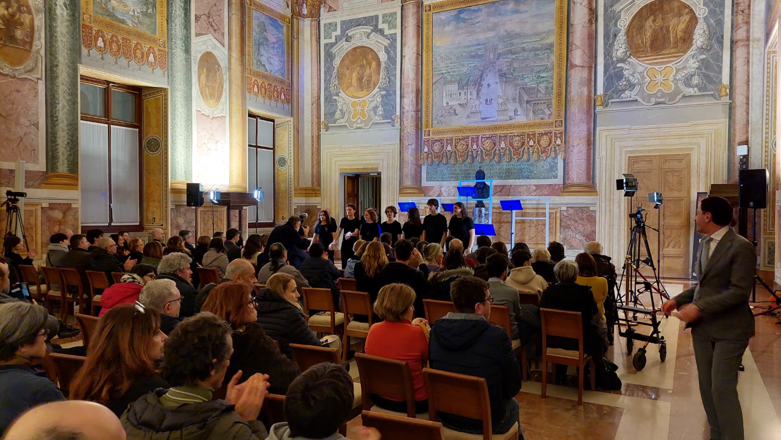 Apostolic vicariate in Rome dedicates its day of arts to Gaza – #Catholic – On Saturday, Feb. 14, the humanitarian situation in Gaza was the focus of a day of the arts at the apostolic vicariate in Rome. In the halls of the Lateran Apostolic Palace, the third edition of the initiative focused on the Gaza Strip, burdened by destruction and loss, where the suffering of its residents calls for ongoing attention. 
 
 The apostolic vicariate in Rome dedicated the third edition of its day of the arts to shedding light on the Gaza Strip. | Credit: Photo by Elias Turk/ACI MENA
 
 The event offered an artistic journey divided into four consecutive performances under the title “If There Were Water.” Father Gabriele Vecchioni, deputy director of the University Pastoral Office at the vicariate, explained at the event that art stands in direct opposition to adaptation and forgetfulness. Shedding light on Gaza, he said, means confronting what the world has heard in recent months: the killing of 64,000 people, including 18,000 children — figures that an arts day insists must not be archived but preserved as an active memory.
 
 The apostolic vicariate in Rome dedicated the third edition of its day of the arts to shedding light on the Gaza Strip. | Credit: Photo by Elias Turk/ACI MENA
 
 In the “Hall of Reconciliation,” the theatrical work “Gaza: Before the Silence” by Francesco D’Alfonso was performed by first-year students of the National Academy of Dramatic Art Silvio D’Amico. Through poetry, music, international reports, and literary excerpts, the performance restored faces and names to the victims. White shrouds and the stark numbers of the tragedy became signs of a collective responsibility shared by all.
 
 The apostolic vicariate in Rome dedicated the third edition of its day of the arts to shedding light on the Gaza Strip. | Credit: Photo by Elias Turk/ACI MENA
 
 Reflection on the suffering of Gaza’s people continued in the “Hall of the Emperors” with the artistic work “Holm” (“Dream”). This project by the National Academy of Dance combined choreography and video. Through the languages of body and image, it opened an intellectual space for reflection on the Palestinian cause, entrusting dance with the task of fostering listening and awareness.
 
 The apostolic vicariate in Rome dedicated the third edition of its day of the arts to shedding light on the Gaza Strip. | Credit: Photo by Elias Turk/ACI MENA
 
 In the Hall of David, “Who Are You? A Beautiful Question,” a work within the relational art movement, directly engaged the audience with the issue. Through words, images, and sounds, it unfolded fragments of memory about what has taken place in the Gaza Strip.
 
 The apostolic vicariate in Rome dedicated the third edition of its day of the arts to shedding light on the Gaza Strip. | Credit: Photo by Elias Turk/ACI MENA
 
 In the Hall of the Apostles, the event hosted the Santa Cecilia Music Institute, with Senka Slipać on the violin and Vehbija Hodžić on the accordion. The musicians performed works by Antonio Vivaldi, Dražan Kosorić, and Vittorio Monti. The artistic journey at the Lateran also included a work titled “Fire,” a collective installation created within a workshop sponsored by Caritas Rome.
 
 The apostolic vicariate in Rome dedicated the third edition of its day of the arts to shedding light on the Gaza Strip. | Credit: Photo by Elias Turk/ACI MENA