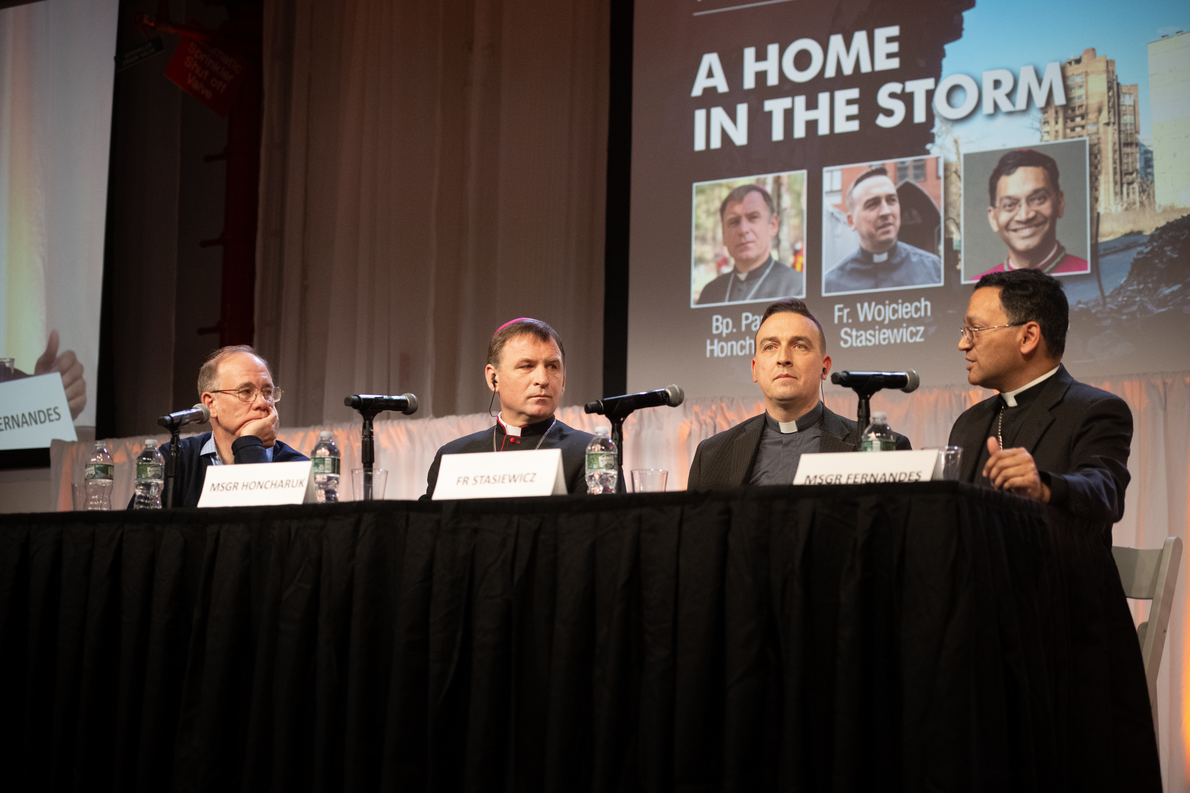 Ukraine bishop at New York Encounter: War begins when man rejects God from his heart – #Catholic – Amid the ongoing Russia-Ukraine war, survival means remaining in relationship with Christ and in community with one another, according to a delegation of Ukrainian Catholic Church leaders who gave their testimony at the New York Encounter on Feb. 14. Bishop Pavlo Honcharuk of Kharkiv and Father Wojciech Stasiewicz, director of Caritas-Spes of the Kharkiv-Zaporizhia Diocese, shared how they have approached survival throughout the four-year conflict that has ravaged their communities.The bishop and priest spoke during a panel moderated by Bishop Earl Fernandes of Columbus, Ohio.
Bishop Pavlo Honcharuk of Kharkiv, Father Wojciech Stasiewicz, and Bishop Earl Fernandes of Columbus, Ohio speak at the New York Encounter, Saturday, Feb. 14, 2026 | Credit: Jeff Bruno
This year’s New York Encounter is centered on the theme “Where Everything Is Waiting for You,” focusing on “the reemerging human desire for authentic belonging amid global isolation, emphasizing how freedom, truth, forgiveness, and dignity foster certainty and openness in true community.” The event will continue through Feb. 15.“We can say that, thanks to God, thanks to our Faith, we have a strong foundation,” said Honcharuk, who compared the current situation in Ukraine to the Titanic. The bishop described the struggles faced by Ukrainians today, including the obliteration of power grids across the country, below-freezing temperatures, and ongoing drone and missile strikes.“We are in the middle of a tempest of suffering and pain,” he said. “In this sense, we're always expecting or waiting for death, but in the midst of all that, we are trying to be able to love, and to help others.”The bishop reflected during his remarks that survival for him has been in keeping busy with the demands of his role, which extend far beyond pastoral care due to the humanitarian aid role the Church in Ukraine has assumed. From traveling to precarious locations to preside over funeral services, to thawing frozen generators, the bishop remains occupied.“If you were to stop and sit and look at it, and try to deepen what is happening, you wouldn’t be able to stand it. There are many instances where people lose their minds, they close in on themselves.” This, he said, “is the most terrible thing.”Honcharuk said Christ’s love is what compels him to remain with his people, and that ultimately, having faith in God is what brings peace.“The beginning of war is in the hearts of men,” the bishop said. “When there is no God, a person does not feel like someone. He has to prove all the time to himself and to others that he is someone. He exploits everything to show that he is someone.”In the end, he said, a person’s encounter with God is where peace begins.Father Stasiewicz also shared how his work with Caritas has acted as both a humanitarian hub for Ukrainians, and as a ministry of faithful presence and community throughout the war. The priest emphasized the need to be in community, especially during conflict, otherwise “you're carrying all this burden by yourself, and you have nobody to help you, or to sustain you.”Papal Nuncio to the U.S. Cardinal Christophe Pierre attended the panel, which took place in the main auditorium of the Metropolitan Pavilion. The event was at maximum capacity, and attendees gave a warm standing ovation to the Ukrainian bishop and priest for several minutes. Ukraine bishop at New York Encounter: War begins when man rejects God from his heart – #Catholic – Amid the ongoing Russia-Ukraine war, survival means remaining in relationship with Christ and in community with one another, according to a delegation of Ukrainian Catholic Church leaders who gave their testimony at the New York Encounter on Feb. 14. Bishop Pavlo Honcharuk of Kharkiv and Father Wojciech Stasiewicz, director of Caritas-Spes of the Kharkiv-Zaporizhia Diocese, shared how they have approached survival throughout the four-year conflict that has ravaged their communities.The bishop and priest spoke during a panel moderated by Bishop Earl Fernandes of Columbus, Ohio.
Bishop Pavlo Honcharuk of Kharkiv, Father Wojciech Stasiewicz, and Bishop Earl Fernandes of Columbus, Ohio speak at the New York Encounter, Saturday, Feb. 14, 2026 | Credit: Jeff Bruno
This year’s New York Encounter is centered on the theme “Where Everything Is Waiting for You,” focusing on “the reemerging human desire for authentic belonging amid global isolation, emphasizing how freedom, truth, forgiveness, and dignity foster certainty and openness in true community.” The event will continue through Feb. 15.“We can say that, thanks to God, thanks to our Faith, we have a strong foundation,” said Honcharuk, who compared the current situation in Ukraine to the Titanic. The bishop described the struggles faced by Ukrainians today, including the obliteration of power grids across the country, below-freezing temperatures, and ongoing drone and missile strikes.“We are in the middle of a tempest of suffering and pain,” he said. “In this sense, we're always expecting or waiting for death, but in the midst of all that, we are trying to be able to love, and to help others.”The bishop reflected during his remarks that survival for him has been in keeping busy with the demands of his role, which extend far beyond pastoral care due to the humanitarian aid role the Church in Ukraine has assumed. From traveling to precarious locations to preside over funeral services, to thawing frozen generators, the bishop remains occupied.“If you were to stop and sit and look at it, and try to deepen what is happening, you wouldn’t be able to stand it. There are many instances where people lose their minds, they close in on themselves.” This, he said, “is the most terrible thing.”Honcharuk said Christ’s love is what compels him to remain with his people, and that ultimately, having faith in God is what brings peace.“The beginning of war is in the hearts of men,” the bishop said. “When there is no God, a person does not feel like someone. He has to prove all the time to himself and to others that he is someone. He exploits everything to show that he is someone.”In the end, he said, a person’s encounter with God is where peace begins.Father Stasiewicz also shared how his work with Caritas has acted as both a humanitarian hub for Ukrainians, and as a ministry of faithful presence and community throughout the war. The priest emphasized the need to be in community, especially during conflict, otherwise “you're carrying all this burden by yourself, and you have nobody to help you, or to sustain you.”Papal Nuncio to the U.S. Cardinal Christophe Pierre attended the panel, which took place in the main auditorium of the Metropolitan Pavilion. The event was at maximum capacity, and attendees gave a warm standing ovation to the Ukrainian bishop and priest for several minutes.