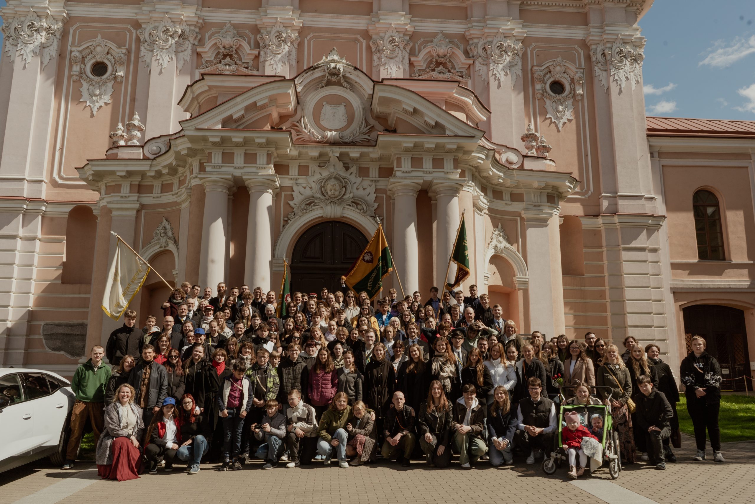 What this 115-year-old Catholic youth movement can teach a secular Europe – #Catholic – VILNIUS, Lithuania — As Catholic youth movements across Europe continue to shrink or retreat from public engagement, Lithuania’s Ateitis Federation stands out as a rare exception: an intergenerational Catholic movement that still forms leaders, sustains disciplined membership, and translates faith into civic presence.Once a lay Catholic resistance movement behind the Iron Curtain, Ateitis at its 115th anniversary offers a rare case study of Catholic youth translating faith into sustained public influence in post-Soviet Europe.From a student journal to a national movementAteitis began as a student magazine, circulated discreetly among Lithuanian university students during the final years of the Russian Empire. Its founders were young Catholics who recognized the increasingly secularized educational and civic model imposed by imperial authorities and refused to accept it as inevitable.
 
 Members of the Ateitis Federation pose inside a church in Vilnius, Lithuania. | Credit: The Ateitis Federation
 
 Eventually the name of the publication became the name of a broader Catholic youth federation, one that wove together faith, intellectual formation, and national renewal. Its essence was summed up in the words that became its motto: “Visa atnaujinti Kristuje” — “To renew all things in Christ.”That phrase echoes the mission of St. Pius X, whose 1903 encyclical E Supremi Apostolatus called for a moral and religious renewal of society in Christ. Ateitis became one of the early movements in the region to adopt that vision explicitly, aligning itself with the wider tradition of Catholic Action.Principles that endureIn 2020, Archbishop Gintaras Grušas of Vilnius, himself the spiritual leader of the Ateitis Federation, reflected publicly on how the movement’s five principles function as a direct response to modern ideological pressures: Catholicism as an answer to relativism, nationality as a safeguard against rootless globalism, family as a response to radical individualism, intellectual excellence against cultural mediocrity, and public engagement as a defense against efforts to exclude faith from the public square.That emphasis on coherent formation helps explain why Ateitis has remained unusually active at a time when many Catholic initiatives struggle to maintain continuity.A demanding membershipIn an era when many young people hesitate to commit to anything long-term, the federation continues to ask for more than occasional participation.“If you want to become a full member, you are asked to take an oath in front of the entire organization,” Ignas Kriaučiūnas, the general secretary of Ateitis, told EWTN News.
 
 A new member receives her ceremonial sash, which signifies membership in the Ateitis Federation, during an oath ceremony. | Credit: The Ateitis Federation
 
 Kriaučiūnas acknowledged that the meaning of this oath has been interpreted in different ways over time, “ranging from an almost monastic vow to a symbolic declaration,” but insisted that it remains “a powerful foundation of our organizational unity,” clearly distinguishing a committed member from someone who simply appreciates the movement.Those who want to take the oath must also complete age-appropriate tasks and commitments intended to demonstrate that they are already living the federation’s principles.Continuity of traditionsLike many youth movements, Ateitis has retreats and major gatherings. But Kriaučiūnas believes the federation’s durability depends on something less dramatic than events: a consistent structure of local life.“Yes, events are fun,” he said, “but success is determined by quiet, steady work.”Ateitis organizes school-aged members into basic units and groups, while students form clubs and even student corporations. The key, he explained, is having “a constant form of activity” — a regular format that gathers people “at least once a month” — which creates both retention and generational continuity.That continuity of formation naturally strengthens one of the hardest things for Catholic initiatives to maintain: meaningful, active partnership between members present now and those who came before.Young members bring energy and enthusiasm. Alumni, in turn, provide resources and support, not merely as donors, but as participants who find renewed meaning through the movement’s ongoing life. “There you have it,” Kriaučiūnas said, “the recipe for successful intergenerational cooperation.”‘To renew all things in Christ’ — not only in church settingsAteitis is often described as possessing a strong intellectual tradition, and for some, that reputation can sound intimidating. But Kriaučiūnas insisted that serious reflection on faith should not feel like a separate, rarefied activity — it must be integrated into everyday life.
 
 Ignas Kriaučiūnas, general secretary of the Ateitis Federation, speaks during an Ateitis conference in Vilnius, Lithuania. | Credit: The Ateitis Federation
 
 “Our motto is: ‘Renew everything in Christ,’” he said. And he stressed that the word “everything” is meant literally: “Not just university or school, but also your home or the gym.”That approach, he explained, shapes a movement in which members from different professions and interests can actually meet, rather than remaining siloed by age or vocation. It also forms Catholics who do not “leave their faith in the churchyard but carry it out into the whole world.”The result, he suggested, is a natural apostolate: meeting people in ordinary spaces — at universities, workplaces, and sports settings — all while showing that Catholic faith is not a limitation on life but an impetus toward growth.“We are Catholics, and that does not prevent us from living,” he said. “On the contrary, it is precisely the impulse of faith that drives us to study, play sports, and live with joy.”A warning for the futureAsked what Catholic leaders across Europe might learn from Ateitis’ 115-year history, Kriaučiūnas hesitated to present the movement as a model of superiority. But he did offer one clear caution: Catholic organizations must resist drifting into structures that dilute their Church identity.He pointed to the temptation to transform Catholic movements into modern NGOs (nongovernmental organizations) “financed by large donors,” a shift that can subtly reorder loyalties and priorities.Ateitis, he said, has managed to avoid becoming dependent on state or international institutions that can pressure movements to “put our loyalty to the Church on the back burner.”
 
 Members of the Ateitis Federation pose with the organization’s flag in the Lithuanian countryside. | Credit: The Ateitis Federation

 
 Yet he also admitted that the movement has faced its own dangers, including the risk of confusing preservation with renewal. Referencing a warning often attributed to Pope Benedict XVI that “the Church, married to her own age, becomes a widow,” Kriaučiūnas said there were times Ateitis forgot to repeatedly ask what it means to renew the world in Christ.“As we sometimes joke,” he said, “we did not renew everything, but preserved everything in Christ.”Looking forward, he expressed confidence in a younger generation of leaders who are not burdened by institutional memory but attentive to the concerns of today. Each era must choose fidelity anew, he said, echoing Benedict’s insistence that “each generation must choose its ideals anew.”“It is not enough to have renewed everything in Christ 115 years ago,” Kriaučiūnas added. “We must do so again now.”