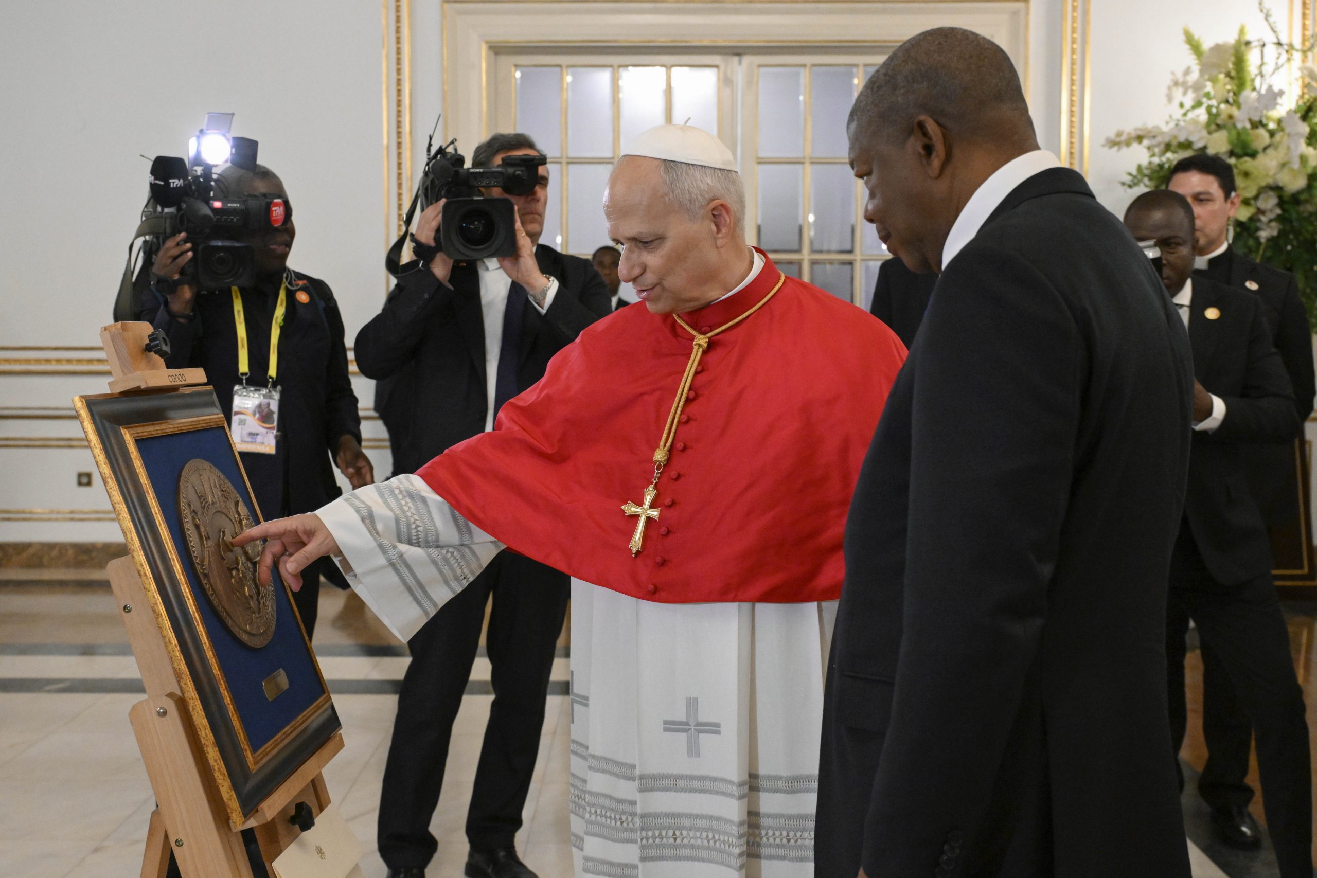 Pope Leo XIV urges Angola to ‘remove the obstacles to integral human development’ #Catholic LUANDA, Angola — Pope Leo XIV on April 18 called on Angola’s leaders and people to “remove the obstacles to integral human development,” urging them to choose the path of the common good, resist exploitative interests, and preserve the hope and joy that, he said, remain among Africa’s greatest treasures.The pope spoke at the presidential palace in Luanda during his meeting with authorities, civil society, and the diplomatic corps, the first public event of the Angola leg of his broader trip to Africa.Arriving in Luanda earlier in the day, Leo traveled by popemobile through jubilant crowds lining the route to the palace. He also held a private meeting with Angolan President João Lourenço before delivering his address.At the outset of his speech, the pope expressed solidarity with those affected by recent flooding in the country.“Before continuing, I would like to offer the assurance of my prayers for the victims of the heavy rains and floods that have struck the province of Benguela, and to express my closeness to the families who have lost their homes,” he said. “I also know that you, the people of Angola, are united in a great chain of solidarity with those affected.”His remarks came against the backdrop of mounting social strains in Angola, including protests last year over fuel price increases, repeated criticism by the country’s bishops over entrenched corruption, and deadly flooding in early April.Leo framed his address around themes that have marked earlier stops on his Africa trip, including peace, reconciliation, the common good, and criticism of those who exploit the continent for personal gain.Speaking in Portuguese, the pope praised the Angolan people for possessing “treasures that cannot be bought or taken away.”“In particular, there dwells within you a joy that not even the most adverse circumstances have been able to extinguish,” he said. This joy, he added, “is no stranger to sorrow, indignation, disappointment and defeat,” yet continues to be reborn in those who have resisted “the seductions of wealth.”The pope sharply criticized patterns of exploitation directed at Africa.“You know well that all too often people have looked — and continue to look — to your lands in order to give, or, more commonly, in order to take,” he said. “It is necessary to break this cycle of interests, which reduces reality, and even life itself, to mere commodities.”Leo described Africa’s joy and hope as “virtues that I would not hesitate to call ‘political,’” because “her young people and her poor continue to dream and to hope.” He said they “are not content with what already exists; they strive to rise above, to prepare themselves for great responsibilities, and to take an active part in shaping their own future.”He also emphasized that authentic social transformation cannot be imposed ideologically.“Indeed, the wisdom of a people cannot be stifled by any ideology, and the longing for the infinite that dwells in the human heart is a principle of social transformation far deeper than any political or cultural program,” he said.The pope said he had come to “listen to and encourage all those who have already chosen the paths of goodness, justice, peace, tolerance and reconciliation,” while also praying “for the conversion of those who choose contrary paths and hinder its harmonious and fraternal development.”Turning to Angola’s natural wealth, Leo warned against what he called a destructive extractive logic.“How much suffering, how many deaths, how many social and environmental disasters are brought about by this logic of extractivism!” he said. At every level, he added, it supports “a model of development that discriminates and excludes, while still presuming to impose itself as the only viable option.”He said Africa “urgently needs to overcome situations and dynamics of conflict and enmity that tear apart the social and political fabric of many countries, fostering poverty and exclusion.”Only encounter allows life to flourish, the pope said, and dialogue must come first, even when disagreements emerge.“Angola can experience great growth if, first of all, those who hold authority in the country believe in the manifold nature of its riches,” he said. “Do not be afraid of disagreement; do not suppress the ideas of the young or the dreams of the elderly; and know how to manage conflicts by transforming them into paths of renewal. Place the common good before every particular interest, never confusing your own part with the whole. History will then vindicate you, even if in the near term some may oppose you.”Leo then returned to the themes of joy and hope, describing them not as merely private sentiments but as forces with public and political consequences.“Despots and tyrants of both body and spirit seek to render souls passive and passions gloomy; they prefer a populace prone to inertia, docile and subservient to power,” he said.Sadness, he argued, leaves people vulnerable to fear, fanaticism, manipulation, and isolation from public life. By contrast, “true joy frees us from such alienation,” he said, calling joy “a gift of the Holy Spirit.”“Joy intensifies life and leads to the creation of community,” the pope said. “Joy knows how to carve paths even in the darkest zones of stagnation and hardship.”He concluded with an appeal for moral and social renewal.“Let us therefore examine our own hearts, dear friends, because without joy there is no renewal; without interiority there is no liberation; without encounter there is no politics; without the other there is no justice.”Leo said the Catholic Church wants to help Angola become “a project of hope” by fostering a just model of coexistence, especially in poor urban neighborhoods and remote rural areas.“Let us remove the obstacles to integral human development, working and hoping together alongside those whom the world has discarded but whom God has chosen,” he said.This story was first published by ACI Stampa, the Italian-language sister service of EWTN News. It has been translated and adapted by EWTN News English.