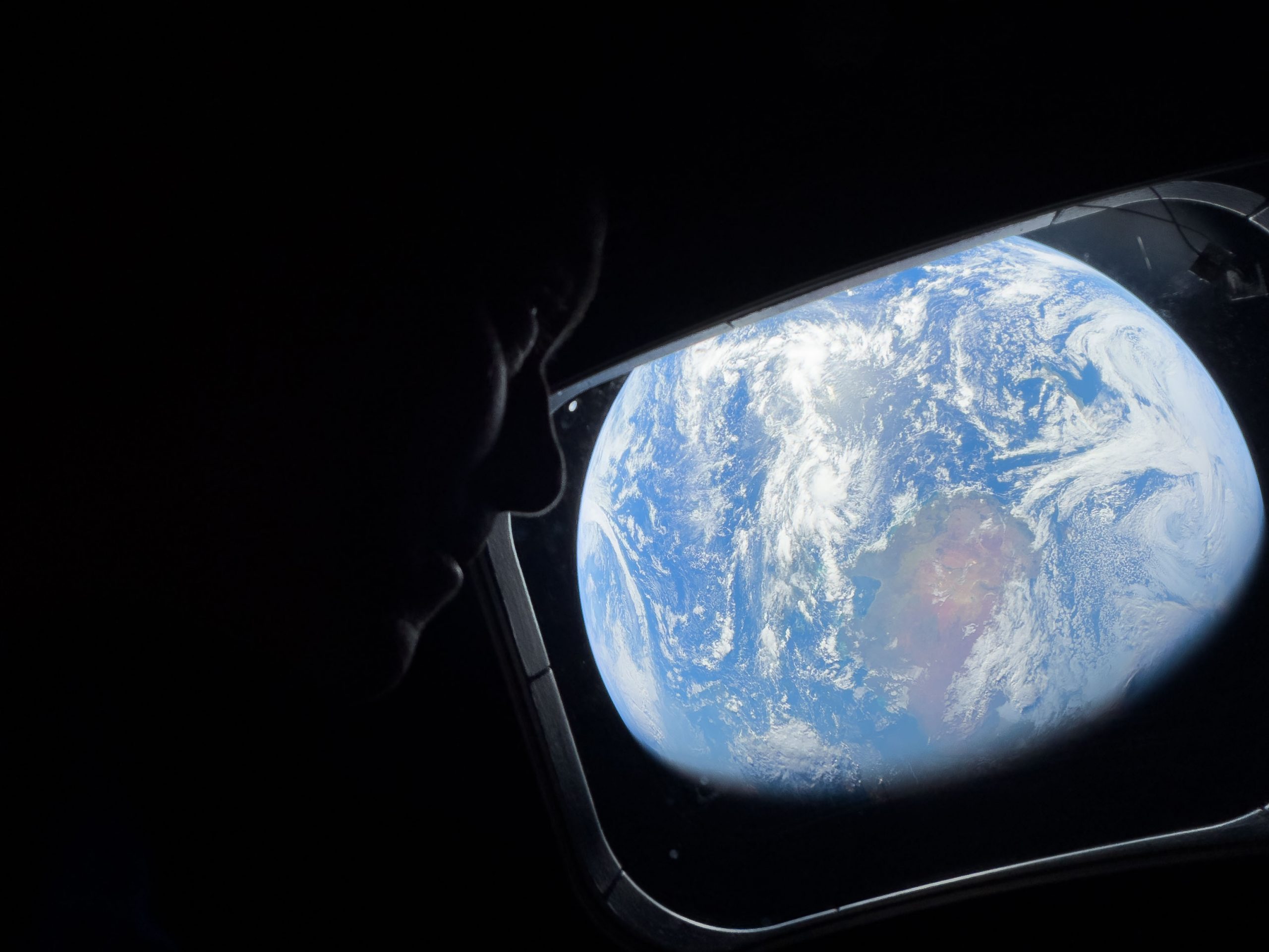 Thinking of You, Earth – NASA astronaut and Artemis II Commander Reid Wiseman peers out of one of the Orion spacecraft’s main cabin windows on April 4, 2026, looking back at Earth, as the crew travels towards the Moon.