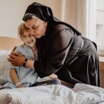 Vilnius’ hospice stands as a living work of Divine Mercy as city prepares to host global congress #Catholic – (OSV News) — Thousands of pilgrims are expected to gather in June in the Lithuanian capital for the sixth World Apostolic Congress on Mercy, or WACOM, a five-day event that has previously been held in cities such as Rome, Kraków, Bogota and Manila.
But in Vilnius, the theme “Building the City of Mercy” is not only a slogan — it is a living heritage.
The June 7-12 congress, organized by the Vatican’s Dicastery for Evangelization, is expected to draw up to 5,000 participants from around the world. The choice of Vilnius as host city is not accidental.
It was here, in 1934, that St. Faustina Kowalska received visions that led to the painting of the first image of Divine Mercy, created by Eugeniusz Kazimirowski. Since then, numerous versions of the image have been painted by other artists, including a popular interpretation by Adolf Hyla in Kraków — both images are now found in churches across the globe.

Click here to subscribe to our weekly newsletter.

The WACOM program will include conferences, testimonies, concerts and daily moments of prayer held across the city. “While in Vilnius, WACOM participants can explore the Way of Mercy — a pilgrimage route linking 14 sacred sites, St. Faustina’s house and the Gate of Dawn chapel, home to a 17th-century icon of the Mother of Mercy,” said Archbishop Gintaras Grušas of Vilnius.
At the Hospice of Blessed Father Michal Sopocko — named after St. Faustina’s confessor — the message of Divine Mercy takes concrete form in daily care for the sick and dying. In fact, the hospice is an indispensable part of the Way of Mercy itself.
The building now housing the Sisters of Merciful Jesus was once the studio of painter Kazimirowski, where he created the first Divine Mercy image. It was also a place associated with Blessed Sopocko, and St. Faustina would come here often.
Sister Michaela Rak, the founder of the hospice, told OSV News — speaking ahead of April 12 Divine Mercy Sunday — that the continuity is clear: The message that began in this place is now lived out daily through care for the over 300 sick and dying patients.
The image of Merciful Jesus “came out of Vilnius and went to the whole world,” she said. “But it is not a decoration on a wall. It is a call: Experience my mercy and bring it where you are sent.”
“For many people, hospice is still something they are afraid of,” Aneta Górniewicz, deputy director of the facility, told OSV News. “But what we try to give here first of all is a sense of safety, dignity and daily care.”
Górniewicz did not plan such a path. She arrived in 2013, just after finishing her studies. “I was looking for work that would have a deeper sense — not just a source of income,” she said. A meeting with Sister Michaela changed everything. “I thought, ‘It’s worth trying.’ And I’ve been here 13 years.”
Sister Michaela, a Polish nun from the Congregation of the Sisters of Merciful Jesus, arrived in Vilnius in early 2000s with the idea of creating the country’s first hospice, which opened in 2009. Sister Michaela built the institution from the ground up, turning it into a place that now serves both adults and children at the end of life.
Inside the hospice, mercy is often expressed in small, almost invisible moments, such as a physiotherapist helping a woman, weakened by cancer, achieve a simple goal: to sit up on her own.
“It may seem like a small thing,” Górniewicz said, “but for that patient it was a huge success, a great achievement.” Other days bring different forms of care — reading books to patients who can no longer hold them, organizing shared moments of music, or even laughter therapy for a young woman with lung cancer. “It looked unusual,” Górniewicz recalled, describing a room filled with staff and patients laughing together. “But it really helped her — both physically and emotionally.”
The hospice also cares for children, some only a few years old. When possible, they are taken outside for walks. Volunteers sit with them, read stories or simply remain present. “Sometimes you don’t need words,” Górniewicz told OSV News. “You hold a hand, you pray, you just are with the person.” She described this as a “language of the heart.”
“We often tell volunteers that not every meeting will be about talking,” she said. “Sometimes it is about silence, about presence.” That presence extends to families as well. Górniewicz remembers one family thanking her simply for a kind welcome. “For me, it felt like something completely natural,” she said. “But for them it was very important — that someone received them with kindness and empathy.”
Moments like these have convinced her that mercy is not abstract. “Mercy is love of the heart,” she said. “Giving your time, your attention, your care to another person.”
Her work has also deepened her faith. Accompanying people at the end of life brings both difficulty and clarity. “From a human perspective, it is hard — especially when young people die,” she said. “But I believe that life does not end, it changes. That gives hope.”
Górniewicz recalled a patient who initially refused any spiritual care: “She said, ‘I don’t want a chaplain, I don’t need confession.’” But as her condition worsened, something shifted. “In the end she asked for the sacraments,” she said. “It was like she took hold of a lifeline.”
For Sister Michaela, this connection between faith and action is essential.
“Jesus looks at everyone with the same gaze — with a gaze of mercy,” she told OSV News. “At the one who loves him and at the one who rejects him.” That gaze, she said, defines what mercy truly is. “To look with the same love at the one who hurts me as at the one who loves me — that is mercy,” she said.
She pointed to another key element: initiative. “Jesus takes the first step,” she said, referring to the Gospel account of the risen Christ entering the room where the disciples were hiding. “He does not accuse them. He says, ‘Peace be with you.’” For Sister Michaela, this movement outward is at the heart of Christian life. “Mercy is to take the first step toward another person,” she told OSV News.
“We look at each person as we look at the image of Jesus — with love,” she said of her hospice. “We take the first step to relieve their suffering.”
Pope Francis made a surprise stop to bless patients of the Blessed Father Sopocko hospice during his 2018 apostolic trip to Vilnius.
“We feed the body, but also care for the soul,” Sister Michaela told OSV News, pointing to the role of the sacraments and spiritual support. If that dimension is lost, she warned, the consequences extend far beyond one institution. “When people lose the source of mercy, the world becomes a place of war, hatred and exploitation,” she said.
The June congress is expected to highlight not only Vilnius’ key religious sites — including the Shrine of Divine Mercy and the Gate of Dawn — but also the lived experience of mercy in the city.
“I would encourage everyone to come and see Vilnius,” she said. “Not only for its beauty, but to discover this spirit of mercy.” She pointed to the congress program, which will include not only conferences but also testimonies and opportunities to encounter works of mercy directly — also at the hospice.
“People today need mercy — even if they don’t always realize it,” she said. “We need to return to its source.”
Katarzyna Szalajko writes for OSV News from Warsaw, Poland.