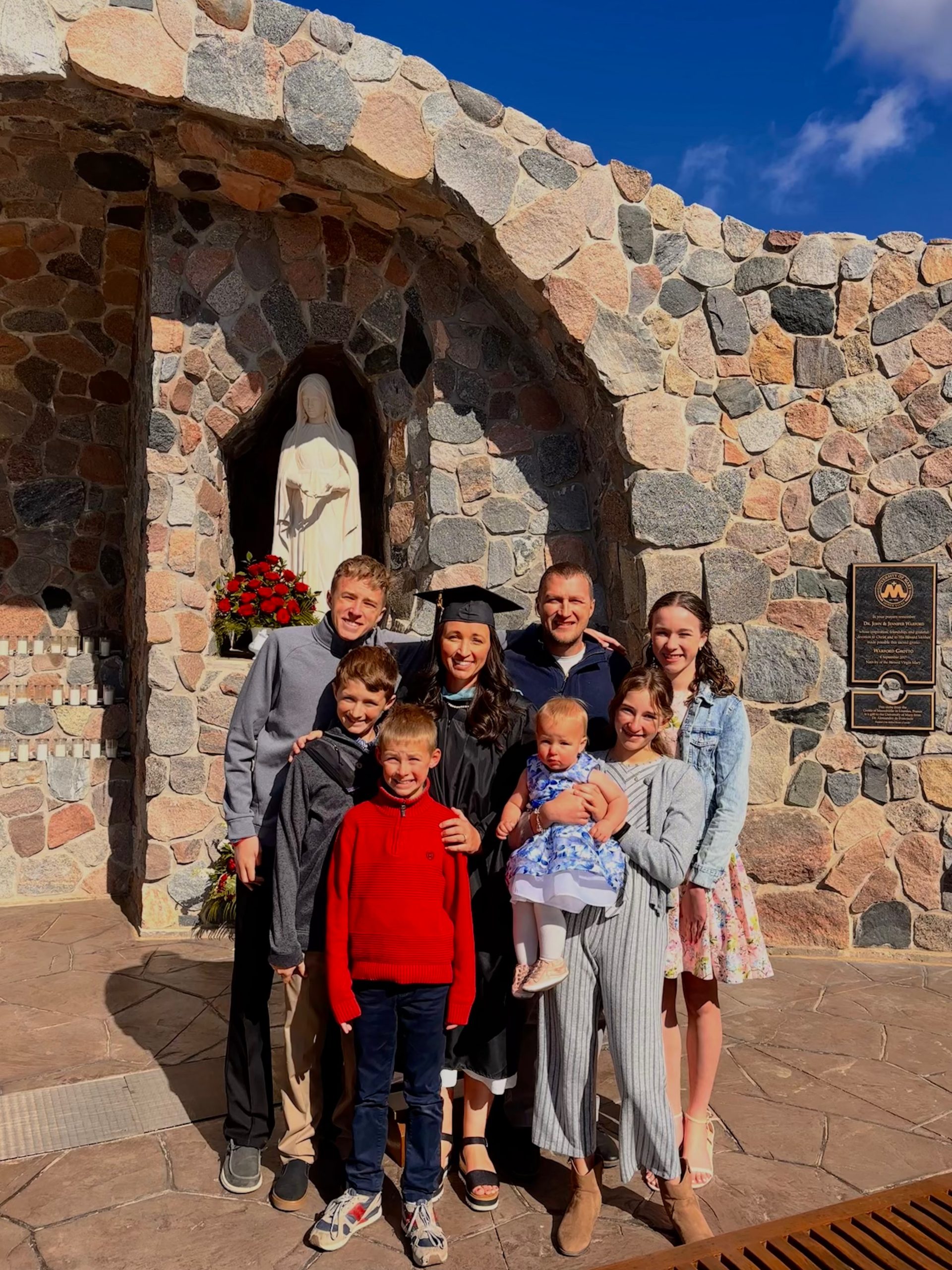After stillbirth loss, mother of 7 returns to school to help others heal #Catholic After experiencing an unimaginable loss, Kelly Helsel felt called to begin a new chapter. Following 17 years as a stay-at-home mother, she returned to school to pursue her dream of becoming a counselor — hoping to offer others the same compassionate support and Catholic guidance that helped bring healing to her own life.In 2023 Helsel’s daughter, Mary Catherine, was stillborn. The experience and grief was ultimately “a huge catalyst to me going back to school,” Helsel told EWTN News.“I think death has an interesting way of snapping your priorities in line,” she said. “And through the death of our daughter, I understood that tomorrow was not promised. And I had been holding this dream very closely for 17 years, just trusting,” she said.“Much of my healing process after the stillbirth of our daughter was helped along by solid Catholic counseling,” she said. “So I just felt a whisper at first, and then I felt like, ‘I can turn around and be this for someone else in need.’ And so I did.”Path back to schoolA native of Arizona, Helsel met her now-husband, Doug, in high school. She then attended Northern Arizona University to receive a bachelorʼs degree in psychology with the hopes of becoming a counselor, but motherhood ultimately became her first priority.“My firstborn … was born during finals week of my bachelorʼs degree,” Helsel said. “I actually had a positive pregnancy test the day before I was scheduled to take the GRE [Graduate Record Examination].”“I just knew that motherhood was the priority and that Godʼs timing would take care of things. So I stayed at home,” she said.Helsel decided to put her plans of working as a counselor on the side and focus on her growing family. She and her husband had seven children over the next 17 years, but after the loss of their sixth child she felt called to switch her plans and return to school. “We just started taking one step in front of the other,” she said. Helsel started by applying to the University of Mary’s master’s program for counseling about six months after her daughter’s passing but was thrown an unexpected “curveball” during the process.“On the feast of the Annunciation, I got in. But then I also had a positive pregnancy test with my daughter, Isabel, on the very same day.”“I remember standing in the bathroom with my husband with my phone in one hand with an acceptance letter, and on the counter was a positive pregnancy test with our seventh baby.”Motherhood provided ‘the skills to be a fantastic student’Despite navigating grief, welcoming a new baby, and continuing to care for the rest of her family, Helsel not only decided to return to school but also opted for a five-semester accelerated program.She graduated on April 25 with a 4.0 GPA and her whole family by her side. It was all possible not in spite of her 17 years as a stay-at-home mom but because of the experience.
 
 Kelly Helsel, her husband Doug Helsel, and their children at her graduation a the University of Mary on April 25, 2026. | Credit: Photo courtesy of Kelly Helsel
 
 “I actually think that motherhood, 17 years of motherhood, gave me the skills to be a fantastic student,” she said. “I learned time management. I learned prioritization. I learned how to ask for help. I learned all kinds of things in the trenches of motherhood that gave me the opportunity to really thrive at UMary.” “I guess the loss of my daughter really showed me that like all things are ‘figure-out-able,’” she said. “When youʼve gone through something like that, it makes you unafraid to do really big things.”“I knew that I could just cannonball into the deep end and we could do this. And my husband was an amazing support throughout the program. But, Isabel was the curveball of all curveballs,” she said.“She was born during Christmas break and I just jumped back in in January. I didnʼt take any time off,” she said. "I would be in a rocking chair breastfeeding her, and my laptop is sitting next to me and Iʼm listening to a lecture.”“I became a pro at using the dictation tool on Microsoft Word” so “I could hold my baby and dictate a paper,” she said. “It was just a really wild time. I learned to be extremely flexible and gentle with myself ... But I just knew God was like, ‘go, go right now.’”“It was super bumpy at some points,“ she said. ”But I chose the University of Mary because I feel like [University of Mary president] Monsignor [James] Shea and the university really put their money where their mouth is in terms of supporting nontraditional students — especially mothers.”“All of my professors were extremely accommodating with extensions if I needed one. A few professors gave me early finals because Isabel was born right at the end of that first semester,” she said. “So the University of Mary was really crucial to my success because everyone was behind me.” Helsel noted that her professors, especially counseling professor Olivia Wedel, and other facility members and students were champions in cheering her “all the way to the finish line.”Waddell “would always remind me that ‘Iʼm surrounded by support,’” Helsel said. “When youʼre super tired and youʼre on your fourth Crock-Pot meal of the week and you donʼt have anymore bandwidth left, I just thought, ‘I am surrounded by support.’”“Jesus is real and his promises are too,” Helsel said. “I just remember really having to trust the Lord in a new way and also having to be very open to my dream not looking exactly like I wanted.”“So yes, I went back to school and I got a masterʼs degree, but it looked absolutely nothing like I thought it was going to, but it was also better, just like he had promised me.”“Your dreams matter to him,“ she said. ”Trust him, and especially Our Lady, with your dreams. Because he wants both. He wants your motherhood and your dreams.”Catholic counseling offers ‘the keys to real human flourishing’Officially a licensed counselor, Helsel is ready to jump in headfirst to help others in need by utilizing the guidance offered by the Catholic Church.“I believe very deeply that the Catholic Church has the keys to real human flourishing,” she said. “So I knew I wanted to become a mental health professional with those guardrails in place, because I benefited so much from Catholic counseling.”“I want to turn back around and help the next woman or couple or … anyone in line that needs to hear the good news, coupled with solid mental health formation. Like St. Thomas Aquinas says, ‘faith and reason.’ We need both.”With her “perinatal mental health training,” Helsel hopes to primarily work in the womenʼs health category “to support other women, pregnant women, postpartum women,” she said. “And obviously I have a love for people who may have lost a child in a particular way.”Helsel is interested in helping those discerning vocations, as her oldest son plans to apply to the priesthood. She is also hoping to support the vocation of marriage as it is “under a particular attack at this time.”To accomplish all of this, Helsel has already started her own private practice called Concordia Counseling.“I chose Concordia because Mary Catherine had a congenital heart condition,” she said. “Concordia means heart to heart or to bring two hearts into harmony. I wanted to honor my baby in heaven and Our Lord with my work. And so I started Concordia Counseling.”“Iʼm just getting it started. I have a caseload of about 10 clients, but Iʼm hoping to accept more,“ Helsel said. ”I know that the work I want to do most of all involves not just mental health but the teachings of the Catholic Church.”“I just think the framework needs to be formed properly, and that is the Catholic understanding of the whole person. And from there we can jump off anywhere,” she said.