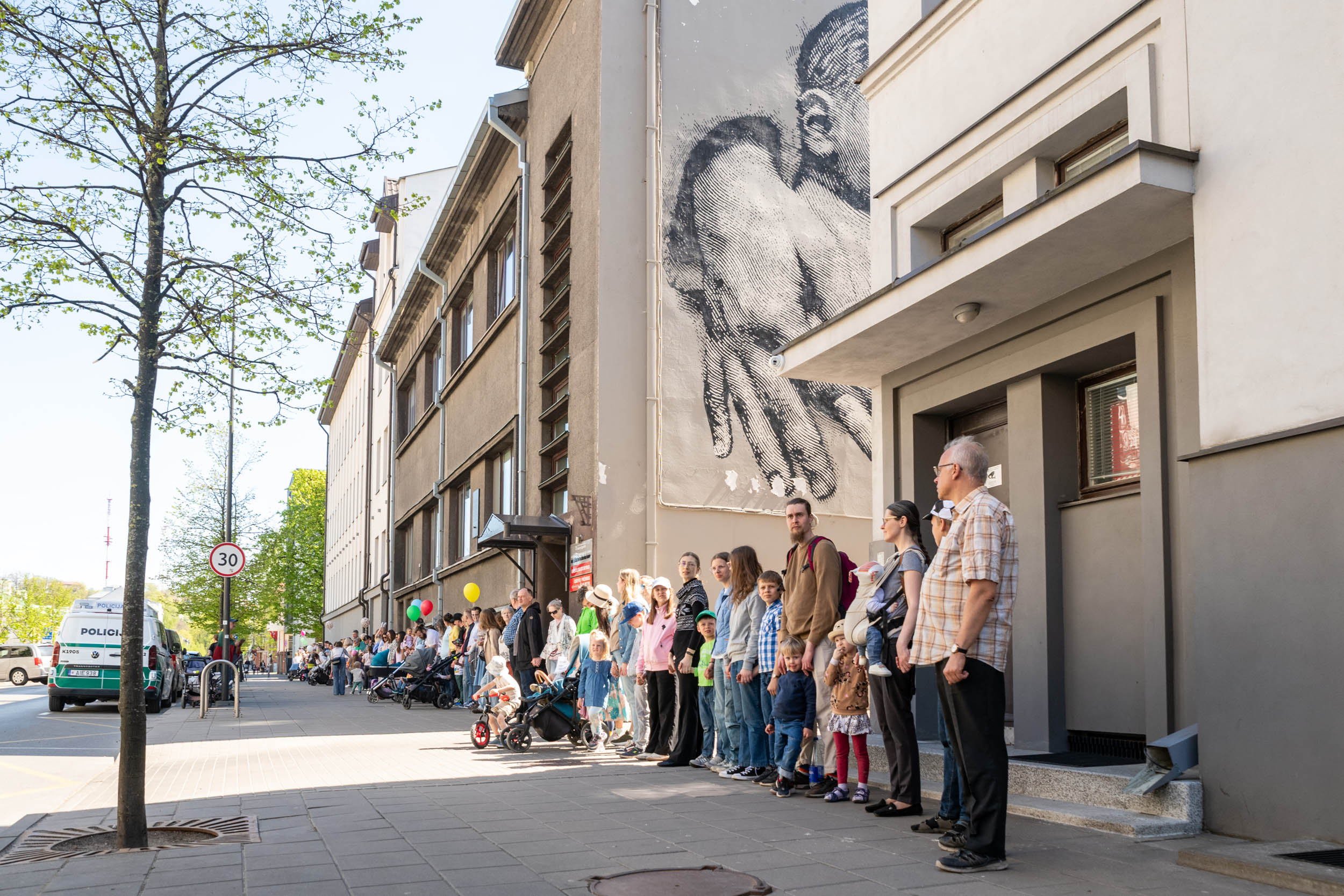 Lithuanian families rally to save pro-life maternity home blessed by John Paul II – #Catholic – VILNIUS, Lithuania — A planned reorganization and merger of Lithuaniaʼs Kaunas Christian Maternity Home (KGN) with its parent hospital have triggered protests from families and pro-life advocates who fear the consolidation will erode the institutionʼs distinctive character and family-focused mission.
 
 A mural on the facade of the Kaunas Christian Maternity Home depicts a newborn cradled in adult hands, a visual signature of the institution’s pro-life identity. | Credit: Photo courtesy of organizers of the “Let’s Save the Kaunas Maternity Home” initiative
 
 KGN is owned by LSMU Kaunas Hospital, which itself is equally divided between two shareholders: the Ministry of Health and the Lithuanian University of Health Sciences (LSMU), each holding 50% ownership. Both shareholders recently approved an optimization plan that would merge KGN into the larger hospital in an effort to streamline operations and reduce costs linked to obstetrics.A century of careFounded in 1926, KGN is the last major maternity home of its kind in Lithuania, focusing on low-risk pregnant mothers. When a report of its family-friendly environment and quality care reached Pope John Paul II in 1997, the impressed pontiff later sent a handwritten greeting blessing the maternity home. To date, it has been consistently rated as one of the best places to give birth in Lithuania.The maternity home has long partnered with Caritas Lithuania, the Archdiocese of Kaunas, and various pregnancy crisis centers to help mothers give birth in a safe and highly personal environment, which most argue is not the case in typical obstetrics wards in major hospitals.
 
 Supporters with balloons line up outside the Kaunas Christian Maternity Home on May 3, 2026, on Mother’s Day in Lithuania, calling for the institution’s preservation. | Credit: Agnietė Čisler
 
 Critics of the merger say that dismantling KGN, given its rich 100-year history, recognition from the late pope, and excellent record, makes families feel unheard and their needs ignored.Why families fear the mergerJarūnė Rimavičė, head of the “Letʼs Save the Kaunas Maternity Home” initiative, which has gathered over 12,000 signatures, told EWTN News that the merger plans would negatively alter the care mothers receive.She explained that the infrastructure at LSMU Kaunas Hospital is less family-friendly and that allocating higher flows of pregnant mothers there would result in “less privacy and less individual attention.” She also pointed out that “some of the delivery rooms and wards do not have private sanitary facilities, which reduces the feeling of privacy and dignity during childbirth.”Rimavičė argued that KGNʼs defining strength lies not only in its family-oriented facilities but also in a care culture built around emotional safety, close personal attention, and respectful communication between staff and mothers.She said this approach is a key reason for the maternity homeʼs high satisfaction among families. Such a culture, she warned, “cannot be simply transferred to another environment by administrative decision alone.”For that reason, she said, merging KGN into a larger multi-specialty hospital “is not an equivalent transfer of services — it is a real deterioration of conditions for women in labor.”An appeal to Pope Leo XIVReports circulated that organizers of the KGN petition had met with Archbishop Georg Gänswein, the apostolic nuncio to the Baltic states. When EWTN News approached him for confirmation, Gänswein acknowledged the meeting, saying he received three representatives who outlined the situation surrounding the Kaunas Christian Maternity Home. He added: “On that occasion they gave me a letter for Pope Leo XIV.”
 
 Gänswein says he prays to Benedict XVI, confirms hope for beatification cause
 
 Organizers later told EWTN News that the letter was an appeal to the Holy Father, detailing their concerns. Gänswein added that he subsequently spoke with the archbishop of Kaunas, informing him of the meeting while discussing the facts of the matter. “He promised to take care on the matter,” he noted.The Archdiocese of Kaunas later issued a statement supporting the petition while highlighting the long-standing role of maternity homes “whose activities are based on Christian values,” in providing both medical and dignity-based care. Kaunas Archbishop Kęstutis Kėvalas also called for cooperation to find solutions to preserve the maternity home.Lithuaniaʼs current healthcare situationOn May 3, marked as Motherʼs Day in Lithuania, supporters gathered outside KGN, calling for its preservation while stressing its importance to families. The demonstration reflects a broader rise in visibility of Lithuaniaʼs pro-life movement, which included a major pro-life march held last year in Vilnius. It also comes as the government continues to discuss measures aimed at supporting families and addressing the countryʼs declining birth rate.
 
 A Lithuanian family attends the Mother’s Day demonstration outside the Kaunas Christian Maternity Home on May 3, 2026, calling for the preservation of the country’s only consistently pro-life maternity facility. | Credit: Juozas Kamenskas
 
 Against this backdrop, Rimavičė highlighted what she described as a clear policy contradiction. “On one hand, the state talks about encouraging birth rates, but on the other hand, it reduces the choices available to mothers and destroys precisely those places that families trust the most and where they feel safe,” she said.Others have also pointed to structural issues in Lithuaniaʼs healthcare system. The current funding model reimburses hospitals largely based on the number of deliveries performed, which critics say incentivizes volume over quality. This approach can contribute to staff burnout, lower levels of individual care, and a tendency to favor faster, more intervention-heavy procedures, such as C-section births over natural births. Rimavičė stated that “maternity wards already face low pay and heavy workloads,” making it difficult to attract and retain staff, and leaving obstetrics systematically undervalued.Observers have pointed to Germany as a potential model for reform. There, funding changes introduced payments that cover fixed costs regardless of delivery volume, helping maintain service availability and reducing incentives tied to the number of births.Rimavičė said her initiativeʼs goal is to preserve the Kaunas Christian Maternity Home as an independent, family-oriented facility offering a “safe alternative between home birth and hospital inpatient birth.” She stressed that the group supports reform, but only if it improves conditions for mothers, including changes to the funding model and more targeted, quality-focused service optimization.