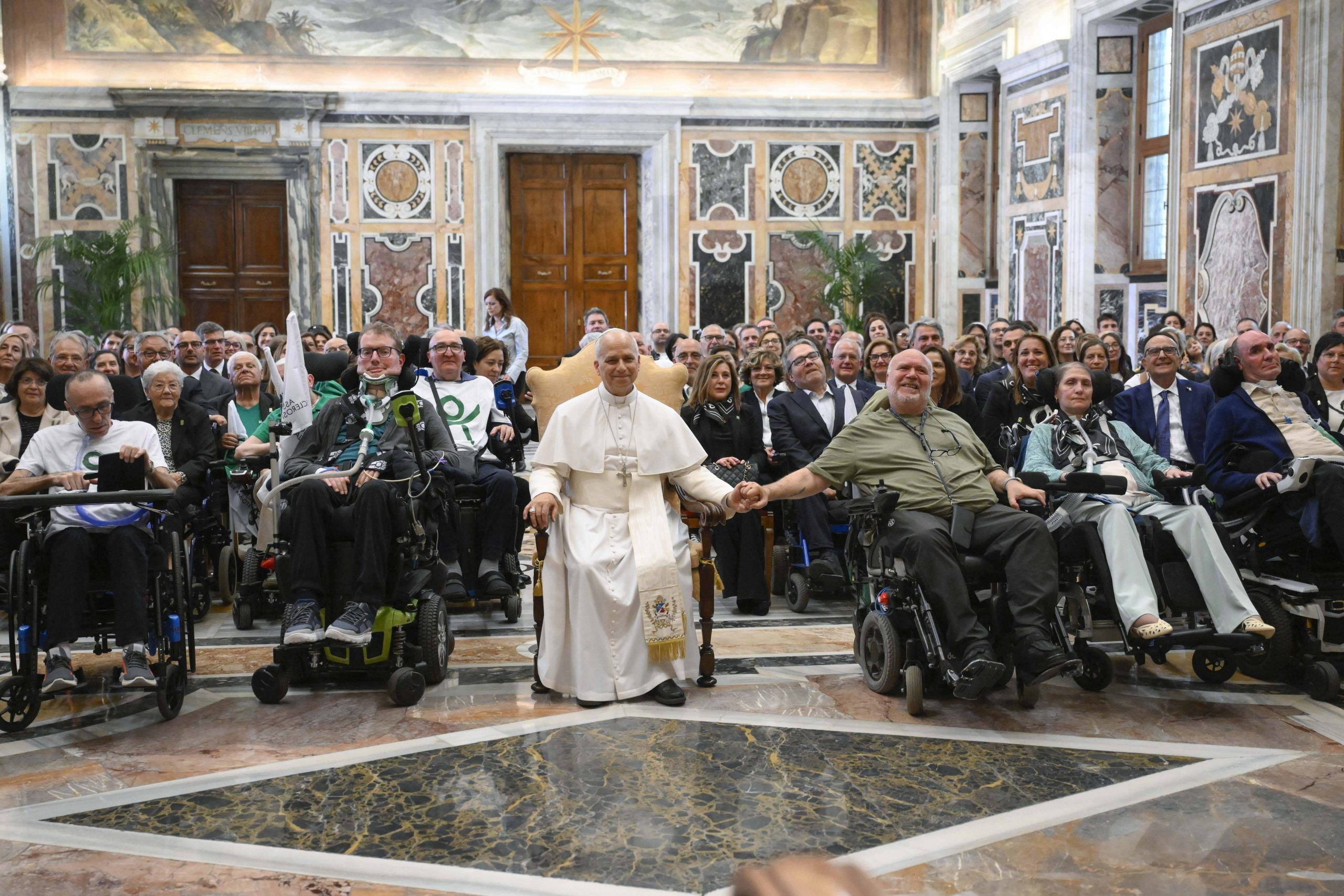 Pope Leo to sick and caregivers: ‘In the various situations of life, no one should be left alone’ – #Catholic – In recognizing the work of the Italian Association for Amyotrophic Lateral Sclerosis (AISLA, by its Italian acronym), Pope Leo affirmed that “in the various situations of life — especially the difficult ones — no one should be left alone.”His words were delivered during an audience with members of the association, which took place Saturday at the Apostolic Palace in the Vatican.The Holy Father stated that the work of AISLA “unites people experiencing an illness—along with their family members and caregivers—in a therapeutic alliance of great closeness and proximity that faithfully reflects the manner in which Jesus himself approached those who suffer.”ALS, also known as Lou Gehrig’s disease, affects nerve cells in the brain, brainstem, and spinal cord that control the movement of voluntary muscles. The disease causes motor nerve cells to deteriorate or die, rendering them unable to send messages to the muscles.Over time, this leads to muscle weakness, spasms, and an inability to move the arms, legs, and body. The condition continues to worsen, and when the muscles in the chest area cease to function, breathing becomes difficult or impossible.The Pope expressed that patients — with commitment, faith, and courage — “bear witness that the goodness and value of life are greater than illness,” and that the challenges it presents “can be faced together, transforming them into special and privileged opportunities to give and receive love.”“Thank you for this! As prophets, you teach everyone the true value of life — and our world desperately needs this message!” Pope Leo said.He strongly emphasized the closeness of the association’s members to the sick — something he considers “very important,” as healthcare requires presence “for the well-being of the person in their various dimensions: biological, psychological, and spiritual.”“The Church deeply senses the value of this ‘closeness’: standing alongside people — wherever they are, in their homes — to offer support, not only in terms of care but also in terms of spirituality, paying special attention to the questions regarding the meaning of suffering — questions that cannot be left unanswered,” he underscored.“In the various situations of life — especially the difficult ones — no one should be left alone; and volunteering, which unites people through generosity, powerfully embodies this value by fostering solidarity and respect, and by responding with gestures of care to the culture of waste and death,” he added.Finally, he invited them to reflect upon the Passion of Jesus, who chose to experience it “as a time of trial, of physical pain and spiritual suffering,” standing in solidarity with humanity to the very end and demonstrating to them “that pain and suffering cannot halt love nor nullify the power of God.”Augustiner Brewery delivers beerOn May 9, Pope Leo also received pilgrims from the Edith Haberland-Wagner Foundation and the Augustiner Brewery, who presented him with beer as a gift. This gesture allowed the Pontiff to offer two points for reflection.
 
 Pope Leo XIV with pilgrims from the Edith Haberland-Wagner Foundation and the Augustiner Brewery, who presented him with beer as a gift. | Credit: Vatican Media
 
 First, he highlighted the pilgrims' connection to the Augustinian Order, to which he himself belongs. In this regard, he recalled the impact of Saint Augustine on his own life — a figure who “reminds us that we all possess gifts and talents bestowed upon us by God, and that our purpose, fulfillment, and joy derive from offering them in loving service to God and to our neighbor.”The Augustiner Brewery is the oldest brewery in Munich and the last to remain privately owned. Its history dates back to 1328.“I hope, therefore, that your pilgrimage not only strengthens you in faith but also inspires you to continue serving your brothers and sisters, especially those most in need,” he affirmed.Then, recalling Pope Francis’s encyclical Laudato Si’, the Holy Father stated that man is called not only to care for creation, but also to “ensure that its resources are always used with wisdom and with a view to justice — an indispensable prerequisite for peace.”“Therefore, upon returning home, I encourage you to continue contributing to the promotion of a just and effective approach to the care of creation, both in the professional and personal spheres, for the common good,” he concluded, imparting his blessing upon all present.