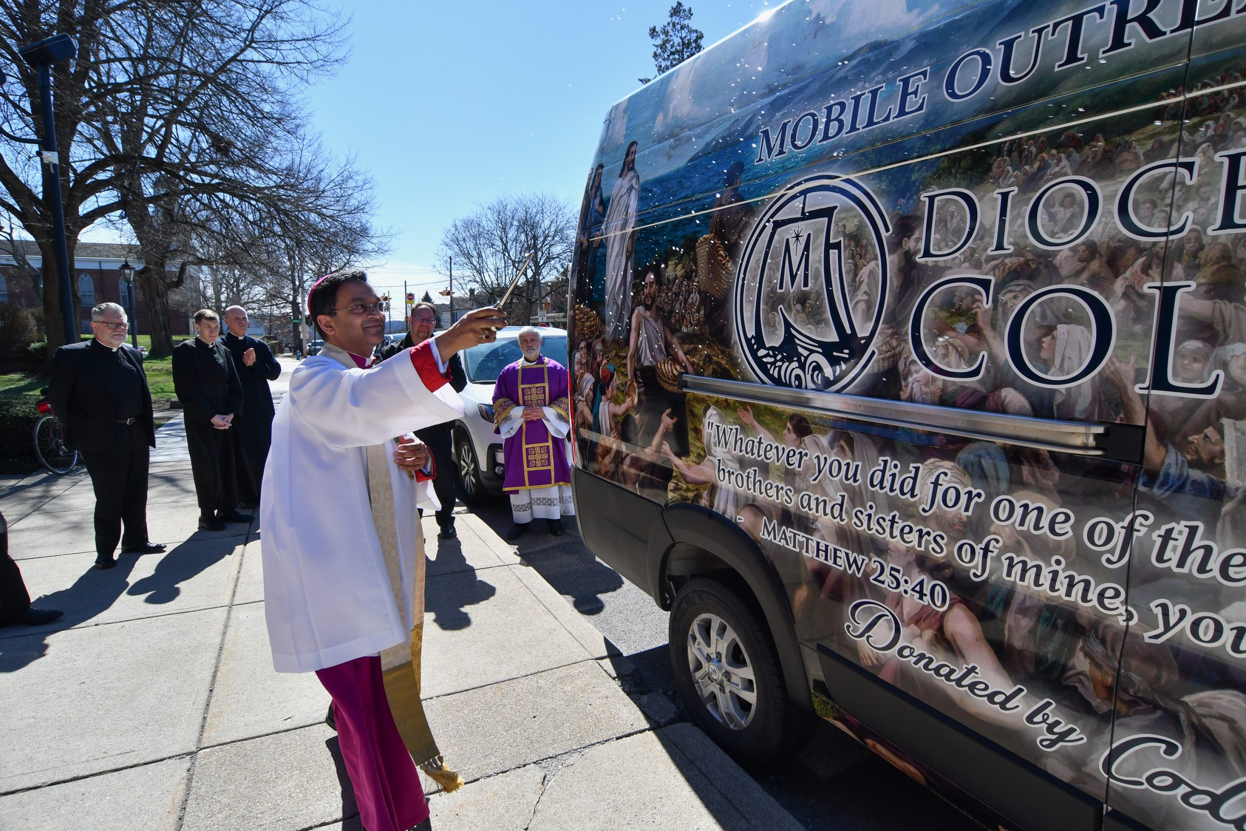 Race car driver’s gift fuels mobile ministry in Ohio diocese - #Catholic - A cargo van donated to the Diocese of Columbus, Ohio, has taken on a new purpose by becoming a mobile outreach ministry delivering food, resources, and the Gospel message to communities in need.Toward the end of 2025, the diocese received the vehicle from Cody Coughlin, a drag racing and stock car driver from Delaware, Ohio. The race car driver “reverted” to the Catholic faith and entered into full communion with the Church a few years back at St. Paul the Apostle in Westerville, Ohio, and was eager to give back to the community.
 
 The Diocese of Columbus, Ohio’s new mobile outreach ministry van, which was donated by drag racing and stock car driver Cody Coughlin. | Credit: Ken Snow, courtesy of the Diocese of Columbus
 
 “I’m deeply humbled and moved to be able to donate a vehicle to help nourish those in need throughout the Catholic Diocese of Columbus,” Coughlin said in the Catholic Times. “It’s a small way to support a mission that truly changes lives, and I’m grateful to be part of something that helps bring food and hope to families who need it most.”From there, the diocese worked to come up with a plan on how the van could be properly used.Deacon Dave Bezuko, director for Catholic Charities in the area and a permanent deacon at Our Lady of Lourdes in Marysville, Ohio, told EWTN News in an interview that they wanted it to be “something that would be useful for the parishes because … we didnʼt want to step on the toes of any of our established diocesan charities and our goal here was twofold: No. 1 letʼs equip parishes with something that they could use to support existing ministries, and [No. 2] take ministry off campus.”Bezuko shared that it was important that the van also be covered in Catholic imagery so that it “could be like a rolling billboard of Catholicism and a sign of the Churchʼs presence out in the community, a sign of Christ’s presence in the community, a sign of hope.”The van now features an image of Jesus at the feeding of the 5,000, an image of the Blessed Virgin Mary, the divine mercy image, a portrait of Mother Teresa, and the words from Matthew 25:40: “Truly, I say to you, as you did it to one of the least of these my brethren, you did it to me.”
 
 The Diocese of Columbus, Ohio’s new mobile outreach ministry van. | Credit: Ken Snow, courtesy of the Diocese of Columbus
 
 The mobile outreach van was then blessed by Bishop Earl Fernandes on March 8 outside of the Basilica of St. Mary of the Assumption in Lancaster, Ohio.In its first couple months of service, the van has been used for a trip to support Mary’s Mission, which serves the needs of the homeless population, and transported approximately 6,000 food items collected by Fisher Catholic High School in Lancaster and the Basilica of St. Mary of the Assumption. The van was also used to transport furniture donated through a furniture ministry run by a deacon at St. John the Evangelist Catholic Church in Logan, Ohio.
 
 Students from Fisher Catholic High School in Lancaster, Ohio, stand outside the mobile outreach ministry van. | Credit: Photo courtesy of Deacon Matt Shaw
 
 The diocese also hopes to use the van as an evangelization tool by taking it to the local Fourth of July parade, high school football games, visits to nursing homes, the annual county fair, and more.“Thereʼs so many different opportunities to be an evangelization tool as well,” Bezuko said.As for what he hopes the impact on the community will be, Bezuko said: “The hope on the impact of the community is No. 1, again, to share that Christ is present in our communities and not just where we have our churches and our schools and our properties.”He added: “One of those things that happens at the end of Mass, the deacon says ‘Go forth, the Mass has ended.’ Weʼre sent out into the community to be the hands and feet of Christ in the world and to be his presence and to take that elsewhere. So, this is a literal opportunity to take Christ, to take our Church, to take that love, that compassion on the road and express it.”The deacon said he hopes this mobile outreach ministry will continue to grow and that one day they will have a “whole fleet of these running around here before too long.”