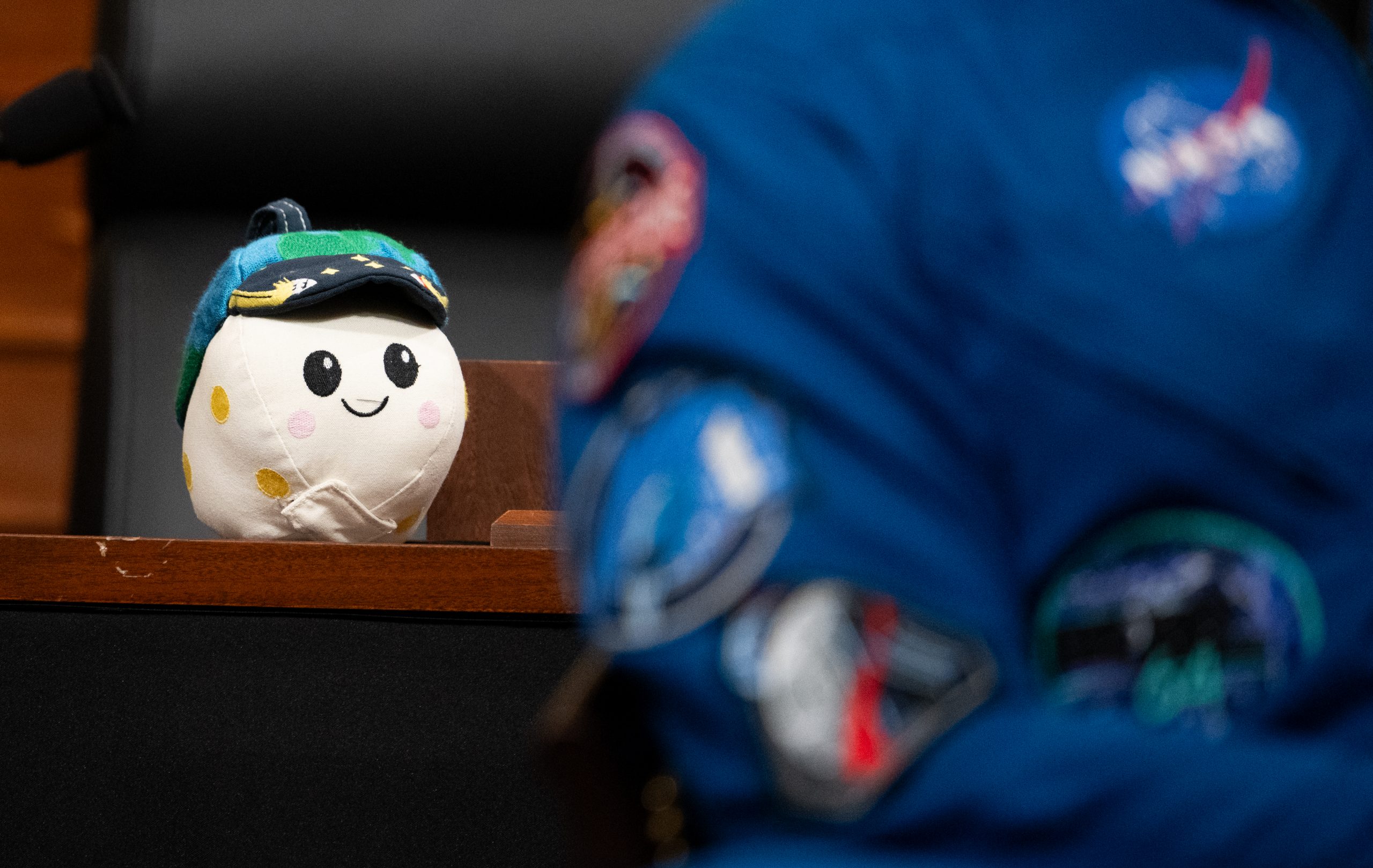 Rise Goes to Washington – “Rise,” the Artemis II zero gravity indicator, is seen sitting on the dais as the Artemis II astronauts speak with congressional staff, Tuesday, May 12, 2026, in Washington.