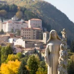 The saint who settled a violent conflict #Catholic – The little town of Cascia, Italy, in the mountainous region of Umbria, is a pilgrimage destination for those wishing to visit the relics of St. Rita of Cascia. Today, St. Rita’s incorrupt remains are housed in the Basilica that bears her name and which was built in the early 20th century. But the town of Cascia has been a destination for pilgrims ever since her death on May 22nd, 1457, and we now celebrate her feast day on May 22nd.
Pilgrims continue to visit Cascia to pray for St. Rita’s intercession just as they have for hundreds of years. Carved into the holy door and façade of the basilica are scenes from her life. Many turn to her in difficult circumstances because she is a patron of impossible causes.
St. Rita wanted to become a nun from a young age but was given in marriage to a violent man embroiled in feuding that consumed Cascia. She worked tirelessly to convert her husband—and there are reports that she succeeded to a degree. But he eventually died a violent death at the hands of his enemies. Rita’s sons took up their father’s feud but later died of illness before they could exact revenge.
Having publicly forgiven her husband’s killers, Rita was happy to see her sons follow in her footsteps on their deathbeds by renouncing their feud and offering forgiveness. She mourned the loss of her sons but hoped to meet them again in heaven, confident in the state of their souls as they passed.

Click here to subscribe to our weekly newsletter.

At the age of 36, Rita decided to pursue her childhood dream of becoming a nun. But the Augustinian convent in Cascia she sought to enter was wary of her association with the feuding families of the town, so the nuns made a stipulation: “Bring peace to Cascia and you may enter the convent.”
What Rita accomplished next earned her the title “Peacemaker of Cascia.” To many, it seemed almost miraculous that she was able to intercede with factions at the center of the conflict to bring peace to the town and earn acceptance into the convent. Some also considered it a near miracle that Abbess Maria Teresa Fasce, head of the Augustinian convent in Cascia from 1920 to 1947, succeeded in having a basilica built to honor the enduring impact of St. Rita’s life.
But those who have shared a devotion to St. Rita throughout the centuries have always understood the importance of her example and her worthiness of such an honor. When St. Rita passed away in 1457, a local carpenter who had been partially paralyzed lamented the simple preparations for burial being made for her.
“If only I were well,” he said, “I would have prepared a place more worthy of you.” The moment he spoke those words, the carpenter was healed, and he crafted a beautiful coffin for her.
Today, the Basilica of St. Rita of Cascia displays her incorrupt body behind glass, where pilgrims can glimpse the miraculous and meditate upon the hope of being restored and reunited in peace with those we love.
The life story of St. Rita of Cascia demonstrates the immense influence we have on the world when we devote ourselves to cultivating peace. St. Rita made such a profound mark that she continues to inspire devotion. May she intercede on behalf of all those who turn to her, especially those in trying circumstances seeking help from God with the most impossible causes.
For free copies of the Christopher News Note NURTURING SEEDS OF FAITH AND HOPE, write: The Christophers, 264 West 40th Street, Room 603, New York, NY 10018; or e-mail: mail@christophers.org
&nbsp;
