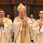 2 newly ordained men thankful for gift of priesthood #Catholic - Sunlight streamed through the stained-glass windows of the Cathedral of St. John the Baptist in Paterson, N.J., on the morning of June 13 as Bishop Kevin J. Sweeney ordained two seminarians as the newest priests of the Paterson Diocese, N.J. In his homily, Bishop Sweeney told the two men that Jesus calls them to “have a missionary spirit in care for those who are most in need.”
The newest priests are Father Lucas Sebastian Mateo Folan, a member of Notre Dame of Mount Carmel Parish in the Cedar Knolls neighborhood of Hanover Township, N.J., and Father Jender Arley Medina Palencia, who was born and raised in Colombia. He served St. Margaret of Scotland Parish in Morristown, N.J., as a temporary deacon before priesthood.
Before the ordination, Father Folan and Father Medina both told BeaconNJ.org that they were “excited” to begin their ministries as priests. The men especially looked forward to consecrating the Eucharist and hearing confessions, and both thanked God for the beautiful “gift of the priesthood.”
Bishop Sweeney, that sunny Saturday, celebrated the English and Spanish ordination Mass, rooted in early Church tradition, at St. John’s, the mother church of the diocese. [Read a detailed description of the Rite of Ordination in the story below.] Priests of the diocese and beyond concelebrated, while deacons and seminarians assisted.
A broad spectrum of well-wishers — including family, friends, priests, parishioners, and diocesan faithful — attended the ordination to support the new priests. The Diocesan Choir and musicians, led by Preston Dibble, diocesan music minister and choir director, performed worship music for the Mass, which was livestreamed for family and loved ones unable to attend.
“Before Christ’s pierced heart, give yourselves entirely to me so that you may love his people with the same love that he loves them,” Bishop Sweeney told the men in his homily. “The priesthood is the love of the heart of Jesus. This love is our pledge as priests. If we surrender and offer ourselves completely, nothing of us will be lost,” he said.
Father Medina celebrated his first Mass as a priest the next day, June 14, at St. Margaret’s in Morristown. His younger sister, Liz, traveled from their native Colombia with her boyfriend for the Masses. Other family and friends watched on a livestream. Father Medina’s first assignment as a priest will be as a parochial vicar of the cathedral.
Father Folan celebrated his first Mass at Notre Dame the next day, in the presence of family and loved ones. In the fall, he will travel to Rome to complete a licentiate in sacred theology, with a focus on fundamental and dogmatic theology, at the Pontifical University of St. Thomas Aquinas. Before that, Father Folan will serve at Lady of Mount Carmel Parish in Boonton, N.J.
Also in his homily, Bishop Sweeney reminded the two men to “be true priests of the New Testament, in order to preach the Gospel. Shepherd God’s people, and celebrate divine worship, especially the Eucharist and reconciliation of the sacraments, especially in the Lord’s sacrifice,” he said.
At the conclusion of Mass, Bishop Sweeney thanked the families of the new priests and their parishes and seminaries, which had representatives present, for nurturing their vocations. He urged the faithful at the liturgy to continue praying for the priests.
Immediately following the recessional at the end of the Mass, the new priests returned to the front of St. John’s altar to give their first blessing as priests to family members and well-wishers.
At the end of Mass, Bishop Sweeney told the new priests, “May God, who founded the Church and guides her still, protect you constantly with his grace that you may faithfully discharge the duties of the priesthood.”
“May he make you servants and a witness and witnesses in the world to divine charity and truth and faithful ministers of reconciliation,” Bishop Sweeney continued. “May he make you two shepherds to provide the living bread and word of life to the faithful so that they may continue to grow in the unity of the one body of Christ,” he said.

Click here to subscribe to our weekly newsletter.

Ordination liturgy steeped in rich traditions of the early Church
The two newest priests for the Paterson Diocese received the Sacrament of Holy Orders and were ordained Saturday, June 13, at the Cathedral of St. John the Baptist in Paterson, N.J., in an ordination liturgy steeped in ceremony and in the rich traditions of the Church.
First, the men were called forward by name. Msgr. Mark Condon, diocesan vicar general, moderator of the Curia, and pastor of Our Lady of the Holy Angels Parish in Little Falls, N.J., requested that Bishop Kevin J. Sweeney ordain the candidates. With that, the bishop announced that he had chosen the candidates for the priesthood, and the congregation greeted the announcement with enthusiastic applause.
Then the priest candidates were asked if they were willing to discharge the Office of Priesthood, to celebrate the mysteries of Christ faithfully and religiously, to preach the Gospel worthily and wisely, to consecrate their lives to God, and to grow closer to Christ. They knelt before the bishop, placing their hands between his, promising obedience to him and his successors.
During the Litany of Saints, the candidates prostrated themselves before the altar and the bishop as a sign of humility and their total reliance on God’s grace. They received the strength of the Holy Spirit as the bishop imposed hands on them in silence. Then, the assembled priests were invited to lay hands on the seven men, part of the ancient sign of ordination.
In the Prayer of Consecration, Bishop Sweeney implored God’s help so the priesthood may continue in the Church. He prayed that the dignity of the priesthood be granted to the candidates. Priests vested the newly ordained with a stole and chasuble. Then the bishop anointed the new priests’ palms with Sacred Chrism as a sign that they now share in Christ’s mission.
Bishop Sweeney accepted the Offertory gifts and then, in turn, handed them to the newly ordained. The new priests and many other diocesan priests were concelebrants at the Mass. Later, the new priests exchanged the sign of peace with Bishop Sweeney and the concelebrating priests as a sign of welcome into the presbyterate.
At the end of the Mass, the new priests gave their first blessing to the Bishop. Then, in front of the altar after Mass, they gave blessings to their family members and friends who had come from near and far to show their support on their ordination day.
BEACON PHOTOS | JOE GIGLI
 [See image gallery at beaconnj.org] &nbsp;