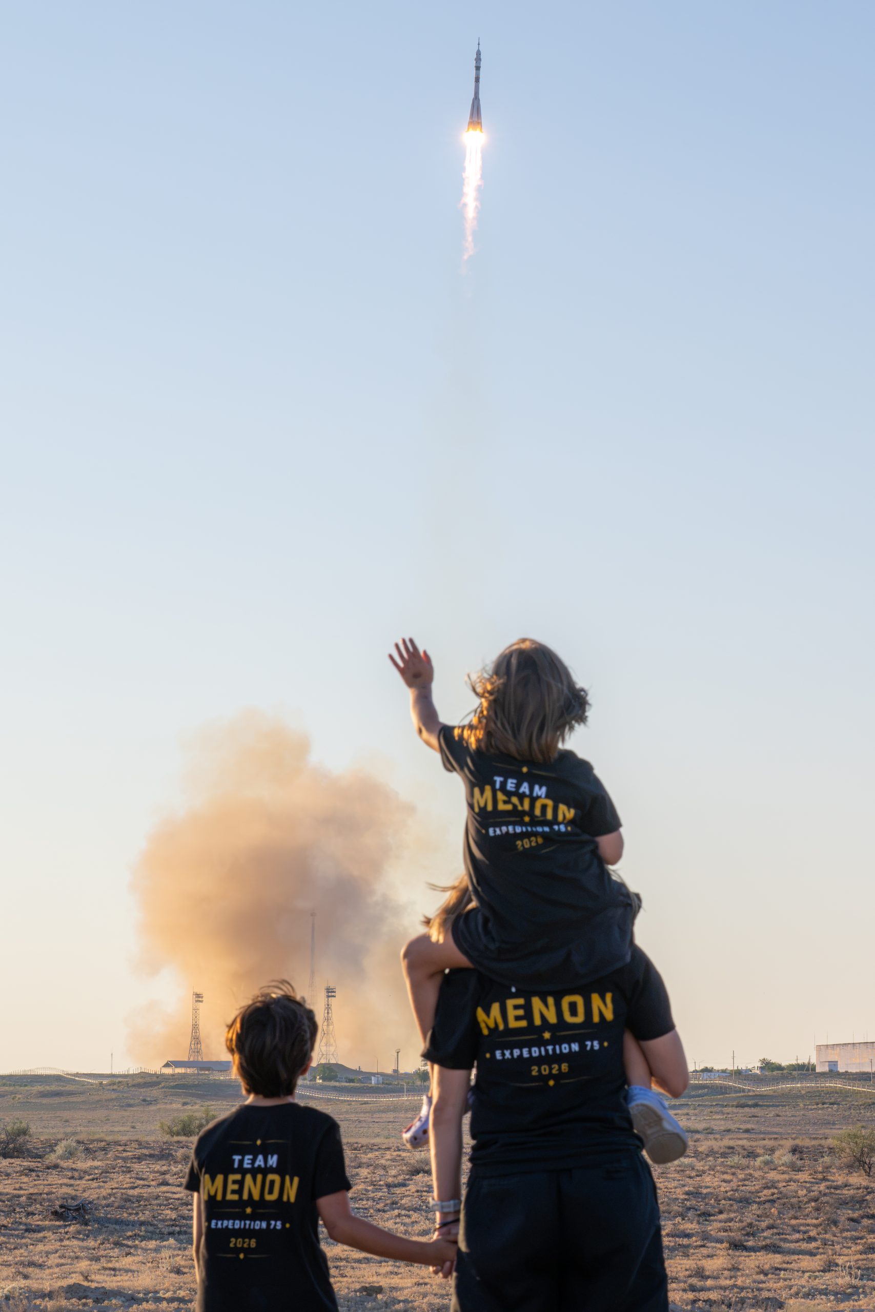 Anil Menon Launches to Space Station – NASA astronaut candidate Anna Menon and her children watch as a Soyuz rocket launches to the International Space Station with Expedition 75 crewmembers NASA astronaut Anil Menon and Roscosmos cosmonauts Pyotr Dubrov and Anna Kikina, Tuesday, July 14, 2026, at Site 31/6 at the Baikonur Cosmodrome in Kazakhstan.