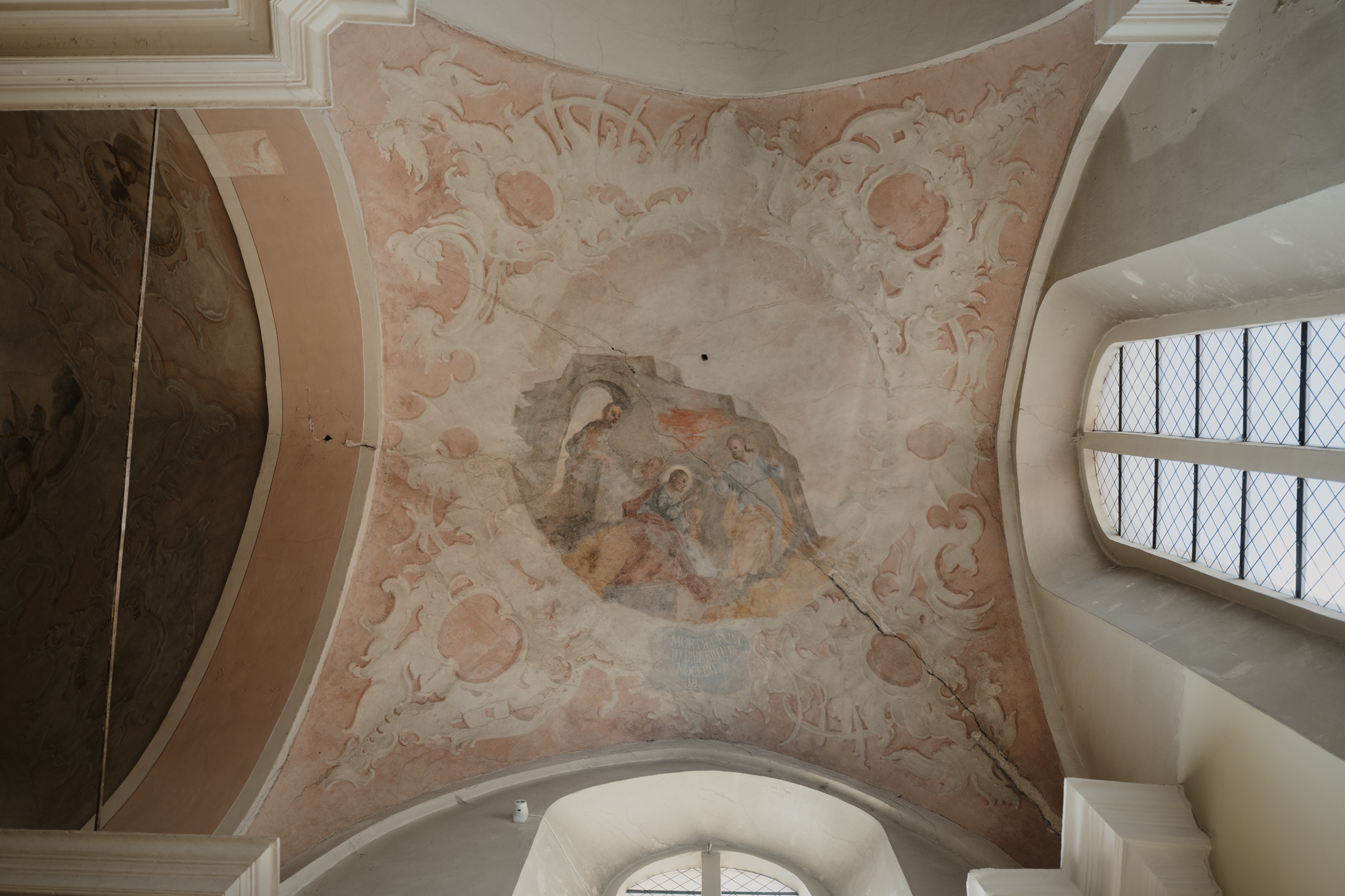 Hidden for 200 years, vast Baroque murals rediscovered in Vilnius’ St. John’s Church – #Catholic – Hidden beneath layers of paint for more than 200 years, one of the largest surviving Baroque Christian painting programs in the Baltic region has emerged inside St. John’s Church at Vilnius University in Lithuania.The church, formally named the Church of St. John the Baptist and St. John the Apostle and Evangelist, has yielded a discovery that is both archaeological and religious.It reveals an almost untouched vision of Catholic worship from the 18th century and offers new evidence that Lithuania was an important center of Europe’s shared Christian artistic tradition.
 
 A fragment of an 18th-century mural depicting a woman holding a child, painted in cool tones, emerges from beneath later overpainting in St. John’s Church in Vilnius, Lithuania. | Credit: Ugnius Bagdonavičius/Vilnius University
 
 Researchers have confirmed that more than 2,000 square meters (21,500 square feet) of original Baroque murals remain preserved beneath later paint layers, making it one of the most authentic surviving Baroque church interiors in the Baltic region.Baroque architecture was heavily promoted by the Catholic Church in the early 1600s to counter the austere architectural style present in Lutheran churches following the Reformation.Starting in Rome, the style spread across Italy, Spain, and Portugal before gaining popularity in Austria, Poland, and Lithuania. Vilnius is today known as the “Rome of the North” because it boasts the largest collection of Baroque architecture in Eastern and Central Europe.A rare moment of discoveryFor lead conservator Indrė Valkiūnienė, the first glimpse of the hidden paintings immediately signaled that the team had uncovered something extraordinary.“Uncovering the first painted figures brought a wonderful sense of discovery,” she told EWTN News. “It immediately became clear that they had been executed with great skill.” The paintings’ refined technique and vivid colors, she said, point to “highly accomplished painters active in 18th-century Vilnius.”“An even greater sense of satisfaction came when we realized that the paintings had escaped later alterations and overpainting until the third decade of the 19th century,” Valkiūnienė said. “They were not overpainted because they could no longer be conserved, but because there was an intention to fundamentally change the decoration of the church interior.”
 
 A fragment of a painted emblem featuring a pink ochre scroll with the Latin inscription “ELEVOR” and the silhouette of a flying black bird appears on a vault of St. John’s Church in Vilnius, Lithuania. | Credit: Ugnius Bagdonavičius/Vilnius University
 
 For Valkiūnienė, the paintings are important as works of art but also as expressions of Christian faith and culture in Vilnius and broader Lithuania.“The character of Vilnius Baroque is expressed not only through architecture but also through the artistic conception of church interiors,” she explained. Churches were designed as unified sacred spaces where marble, stucco sculpture, gilding, and monumental paintings together proclaimed the Christian message.The newly investigated vault paintings formed part of that unified program.Historically across Europe, many Baroque church interiors have been repeatedly restored or repainted, leaving scholars to distinguish original artwork from later interventions. At St. John’s Church, the paintings were simply concealed.Researchers have now identified the arrangement of scenes depicting the lives of St. John the Baptist and St. John the Evangelist while also establishing the original color scheme and assessing the condition of the concealed paintings. This information will guide any future restoration.For visitors today, Valkiūnienė believes the discovery places Lithuania firmly within Europe’s Christian artistic heritage.A Jesuit church at the heart of LithuaniaThe discovery carries added significance because St. John’s Church stands at the heart of Vilnius University, one of Eastern Europe’s oldest universities.Founded by the Jesuits in 1579, it was one of just 23 Jesuit universities in Europe between the 16th and 18th centuries and, for nearly 200 years, the easternmost university on the continent. From there, it served as a leading center of Catholic learning during the Counter-Reformation, shaping the intellectual and spiritual life of the region.The university also has close ties to one of the Church’s best-known modern devotions. Among its professors was Blessed Michał Sopoćko, the confessor and spiritual director of St. Faustina Kowalska, who encouraged the Polish nun to record her mystical experiences and helped spread the message of divine mercy throughout the Church.For centuries, St. John’s Church also hosted royal ceremonies and gatherings of nobles, reflecting its central place in the religious and civic life of Lithuania.More than restoring artFor Jesuit Father Aldonas Gudaitis, the chaplain of Vilnius University, the discovery is about far more than recovering historical paintings.“The beauty of Baroque inspires young people to admire art,” he said. That fascination, he explained, often encourages them not only to explore Christian artistic traditions more deeply but also awakens an interest in the Christian faith itself. He believes the restoration also carries a powerful message for Lithuania, whose churches suffered greatly during decades of Soviet occupation.
 
 Baroque buildings fill the skyline of Vilnius Old Town in Lithuania, a city known as the “Rome of the North.” | Credit: Augustas Didzgalvis
 
 Under the USSR, St. John’s Church was closed to worshippers, damaged while being stripped of its religious functions, and later repurposed as a warehouse.Across the country, Gudaitis explained, restoring what was damaged or hidden has become a source of hope for many people. Comparing the process to the Catholic sacrament of reconciliation, Gudaitis said that just as forgiveness frees a person to live without the burden of guilt, restoring sacred art brings a similar spiritual renewal to communities.“The restoration of art in churches enriches people spiritually,” he said. “It strengthens the hope that even a violent occupation cannot destroy what is beautiful and cherished.”That message may ultimately become the discovery’s greatest legacy.Beyond revealing one of the Baltic region’s largest surviving Baroque painting programs, the hidden murals of St. John’s Church remind Catholics that beauty created for the glory of God can endure through wars, occupations, and changing fashions, all while waiting patiently to inspire a new generation.