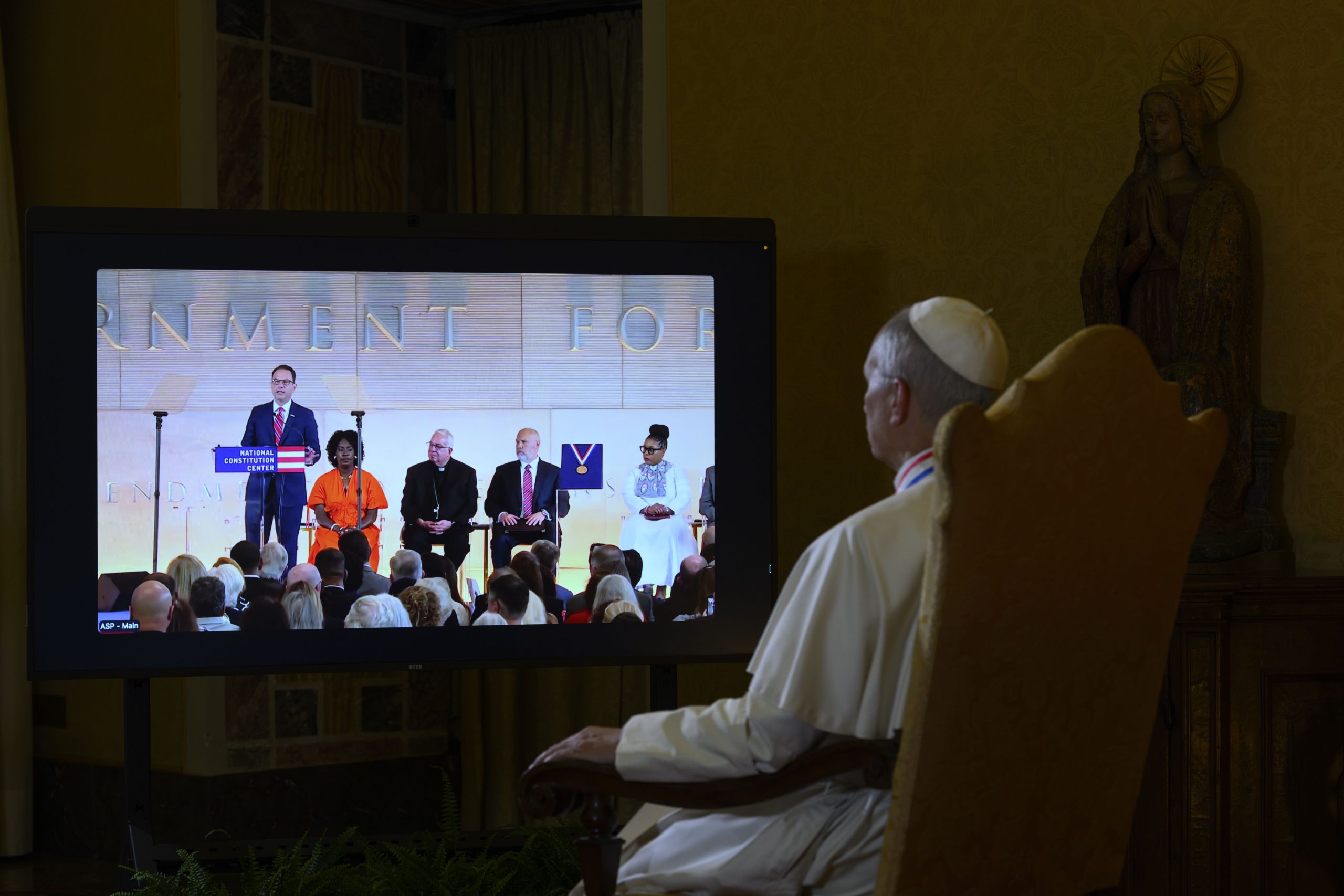 Pope Leo XIV accepts Constitution Center’s 2026 Liberty Medal: ‘I am honored’ #Catholic PHILADELPHIA — Pope Leo XIV said he was “honored” to accept the 2026 Liberty Medal from the National Constitution Center (NCC) in livestreamed remarks delivered for the ceremony in Philadelphia on July 3.“I am honored to accept the Liberty Medal of the National Constitution Center in this year that marks the 250th anniversary of the founding of the United States of America with the signing of the Declaration of Independence on July 4, 1776,” the Holy Father said.Leo was born in Chicago but earned a bachelor’s degree at Villanova University in the Philadelphia suburbs. The NCC presented the award to the pontiff in person at the Vatican on April 30, ahead of the ceremony.In his remarks, Leo thanked those gathered in Philadelphia for the occasion. The NCC building overlooks the Liberty Bell and Independence Hall, where the country’s founders developed and adopted the Declaration of Independence, the Constitution, and the Bill of Rights.“As a son of this great country, founded by courageous men and women who dreamed of liberty and of a better life for themselves and for their children, I join you in asking God’s blessings upon America’s future, that the lofty ideals enshrined at the beginning of the Declaration of Independence may continue to guide the flourishing of the nation in unity, justice, and peace,” Leo said.“From our youth, most of us have admired the eloquence of those words, with their resounding appeal to the law of nature and to nature’s God as the basis of their assertion that all men and women are created equal and endowed by their Creator with certain inalienable rights, including the right to life, liberty, and the pursuit of happiness,” he said.The pontiff said that although the text employed “the language of the Enlightenment,” the claim is “ultimately grounded in an understanding of the human person inspired by the great biblical vision of man and woman being created in the divine image.”“It is indeed here that we discover the basis of human dignity; dignity which precedes the establishment of any state and whose custody constitutes its very purpose,” Leo said.
Pope Leo XIV watches the livestreamed ceremony between the Vatican and the National Constitution Center in Philadelphia on July 3, 2026. | Credit: Vatican Media
Respecting the right to life “in every form and condition,” he said, is directly tied to the nation’s vitality. He said society must cultivate a reverence for life that “sways the hearts of individuals and inspires laws that recognize and safeguard this gift from the moment of conception to natural death.”The right to liberty, the pontiff said, is much deeper than simply doing what one wants. It is “founded upon the human person’s capacity to know the truth and adhere to what is good, even at great cost — a sacrifice well known to many who have labored to shape this country,” he said.“The desire for truth and freedom, as well as the very pursuit of happiness, continues to inspire people of all generations to ask fundamental questions regarding the meaning of life, our ultimate purpose, and indeed about God, and it is proper for magnanimous hearts to endeavor to answer these questions with sincerity,” Leo said.The Holy Father said that religious freedom, to be “free from fear and coercion, as enshrined in the First Amendment to the United States Constitution,” is needed to answer those questions.“It is my hope that this tradition will continue to bear fruit in a public discourse marked by moderation, respect for the views of others, and an ongoing effort to find common ground in promoting the cause of peace and reconciliation, at home and abroad,” he added.The pope said he is praying that the 250th anniversary of the United States “may be the occasion of a solemn recommitment to these ideals that have made America a country that values peace and prosperity, a country characterized by generosity and nobility of heart.”Archbishop Perez, Gov. Shapiro speakThe ceremony was attended by a few hundred guests and included other speakers, such as Philadelphia Archbishop Nelson J. Perez, Pennsylvania Gov. Josh Shapiro, state Attorney General Dave Sunday, Philadelphia Mayor Cherelle L. Parker, and local Christian, Muslim, and Jewish religious leaders.Perez said throughout Leo’s life — as priest, bishop, cardinal, and pope — he has defended the “inherent dignity of all people and building pathways to peace,” including a defense of religious freedom.“True freedom stems from defending dignity and the value of every human being,” he said.Perez told EWTN News following the event that the pope’s words “bring us back to our origins” as Americans regarding the right to life, liberty, and the pursuit of happiness.“It was wonderful to hear him once again bring us back to center, that we all were created in a very image and likeness of God,” the archbishop said. “Our human dignity and our rights flow from that. They flow from being created in Godʼs image and likeness and from there flows our freedom and the heart that seeks God.”“Itʼs a wonderful day for Philadelphia,” Perez said. “Itʼs a wonderful day for the country. Itʼs a wonderful day for the world.”Shapiro congratulated the pope on receiving the award and thanked the Holy Father, on behalf of Pennsylvania, “for using your voice, your power, to advance religious liberty for all people.”The ceremony included the ringing of a replica of the Liberty Bell just outside the building. It was rung by Sunday, the attorney general, who recalled the words of Benjamin Franklin when the Founding Father was asked what form of government they had created after the constitutional convention: “A republic, if you can keep it.”“Our Constitution is the rock upon which we will build in the next 250 years,” Sunday said. Pope Leo XIV accepts Constitution Center’s 2026 Liberty Medal: ‘I am honored’ #Catholic PHILADELPHIA — Pope Leo XIV said he was “honored” to accept the 2026 Liberty Medal from the National Constitution Center (NCC) in livestreamed remarks delivered for the ceremony in Philadelphia on July 3.“I am honored to accept the Liberty Medal of the National Constitution Center in this year that marks the 250th anniversary of the founding of the United States of America with the signing of the Declaration of Independence on July 4, 1776,” the Holy Father said.Leo was born in Chicago but earned a bachelor’s degree at Villanova University in the Philadelphia suburbs. The NCC presented the award to the pontiff in person at the Vatican on April 30, ahead of the ceremony.In his remarks, Leo thanked those gathered in Philadelphia for the occasion. The NCC building overlooks the Liberty Bell and Independence Hall, where the country’s founders developed and adopted the Declaration of Independence, the Constitution, and the Bill of Rights.“As a son of this great country, founded by courageous men and women who dreamed of liberty and of a better life for themselves and for their children, I join you in asking God’s blessings upon America’s future, that the lofty ideals enshrined at the beginning of the Declaration of Independence may continue to guide the flourishing of the nation in unity, justice, and peace,” Leo said.“From our youth, most of us have admired the eloquence of those words, with their resounding appeal to the law of nature and to nature’s God as the basis of their assertion that all men and women are created equal and endowed by their Creator with certain inalienable rights, including the right to life, liberty, and the pursuit of happiness,” he said.The pontiff said that although the text employed “the language of the Enlightenment,” the claim is “ultimately grounded in an understanding of the human person inspired by the great biblical vision of man and woman being created in the divine image.”“It is indeed here that we discover the basis of human dignity; dignity which precedes the establishment of any state and whose custody constitutes its very purpose,” Leo said.
Pope Leo XIV watches the livestreamed ceremony between the Vatican and the National Constitution Center in Philadelphia on July 3, 2026. | Credit: Vatican Media
Respecting the right to life “in every form and condition,” he said, is directly tied to the nation’s vitality. He said society must cultivate a reverence for life that “sways the hearts of individuals and inspires laws that recognize and safeguard this gift from the moment of conception to natural death.”The right to liberty, the pontiff said, is much deeper than simply doing what one wants. It is “founded upon the human person’s capacity to know the truth and adhere to what is good, even at great cost — a sacrifice well known to many who have labored to shape this country,” he said.“The desire for truth and freedom, as well as the very pursuit of happiness, continues to inspire people of all generations to ask fundamental questions regarding the meaning of life, our ultimate purpose, and indeed about God, and it is proper for magnanimous hearts to endeavor to answer these questions with sincerity,” Leo said.The Holy Father said that religious freedom, to be “free from fear and coercion, as enshrined in the First Amendment to the United States Constitution,” is needed to answer those questions.“It is my hope that this tradition will continue to bear fruit in a public discourse marked by moderation, respect for the views of others, and an ongoing effort to find common ground in promoting the cause of peace and reconciliation, at home and abroad,” he added.The pope said he is praying that the 250th anniversary of the United States “may be the occasion of a solemn recommitment to these ideals that have made America a country that values peace and prosperity, a country characterized by generosity and nobility of heart.”Archbishop Perez, Gov. Shapiro speakThe ceremony was attended by a few hundred guests and included other speakers, such as Philadelphia Archbishop Nelson J. Perez, Pennsylvania Gov. Josh Shapiro, state Attorney General Dave Sunday, Philadelphia Mayor Cherelle L. Parker, and local Christian, Muslim, and Jewish religious leaders.Perez said throughout Leo’s life — as priest, bishop, cardinal, and pope — he has defended the “inherent dignity of all people and building pathways to peace,” including a defense of religious freedom.“True freedom stems from defending dignity and the value of every human being,” he said.Perez told EWTN News following the event that the pope’s words “bring us back to our origins” as Americans regarding the right to life, liberty, and the pursuit of happiness.“It was wonderful to hear him once again bring us back to center, that we all were created in a very image and likeness of God,” the archbishop said. “Our human dignity and our rights flow from that. They flow from being created in Godʼs image and likeness and from there flows our freedom and the heart that seeks God.”“Itʼs a wonderful day for Philadelphia,” Perez said. “Itʼs a wonderful day for the country. Itʼs a wonderful day for the world.”Shapiro congratulated the pope on receiving the award and thanked the Holy Father, on behalf of Pennsylvania, “for using your voice, your power, to advance religious liberty for all people.”The ceremony included the ringing of a replica of the Liberty Bell just outside the building. It was rung by Sunday, the attorney general, who recalled the words of Benjamin Franklin when the Founding Father was asked what form of government they had created after the constitutional convention: “A republic, if you can keep it.”“Our Constitution is the rock upon which we will build in the next 250 years,” Sunday said.