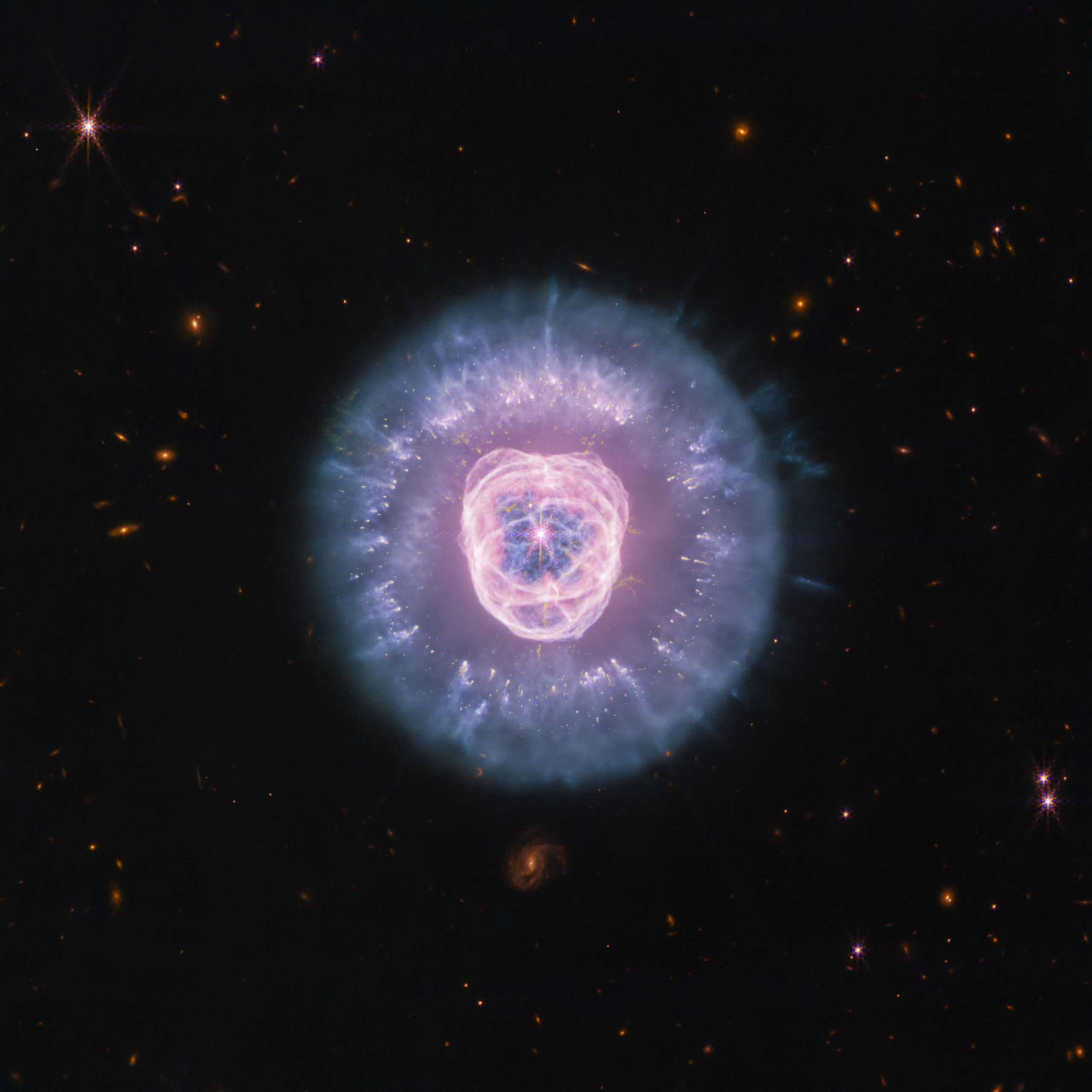Lion Nebula Roars in Webb’s Sights – NASA’s James Webb Space Telescope imaged the planetary nebula NGC 2392, the Lion Nebula, using the observatory’s NIRCam and MIRI instruments. The central star’s remains are responsible for the nebula’s structure, including a lion face-shaped bubble of ionized gas and dust “mane.”