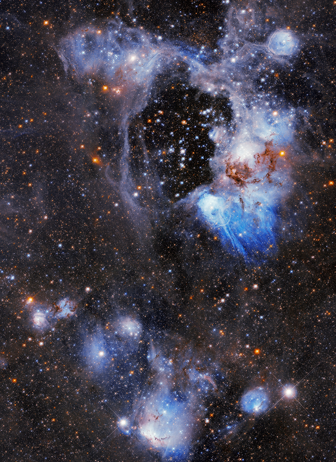 Superbubble in the Large Magellanic Cloud – N44 is a complex nebula filled with glowing hydrogen gas, dark lanes of dust, massive stars, and many populations of stars of different ages. One of its most distinctive features, however, is the dark, starry gap called a “superbubble,” visible in this Hubble Space Telescope image in the upper central region. Superbubble in the Large Magellanic Cloud – N44 is a complex nebula filled with glowing hydrogen gas, dark lanes of dust, massive stars, and many populations of stars of different ages. One of its most distinctive features, however, is the dark, starry gap called a “superbubble,” visible in this Hubble Space Telescope image in the upper central region.